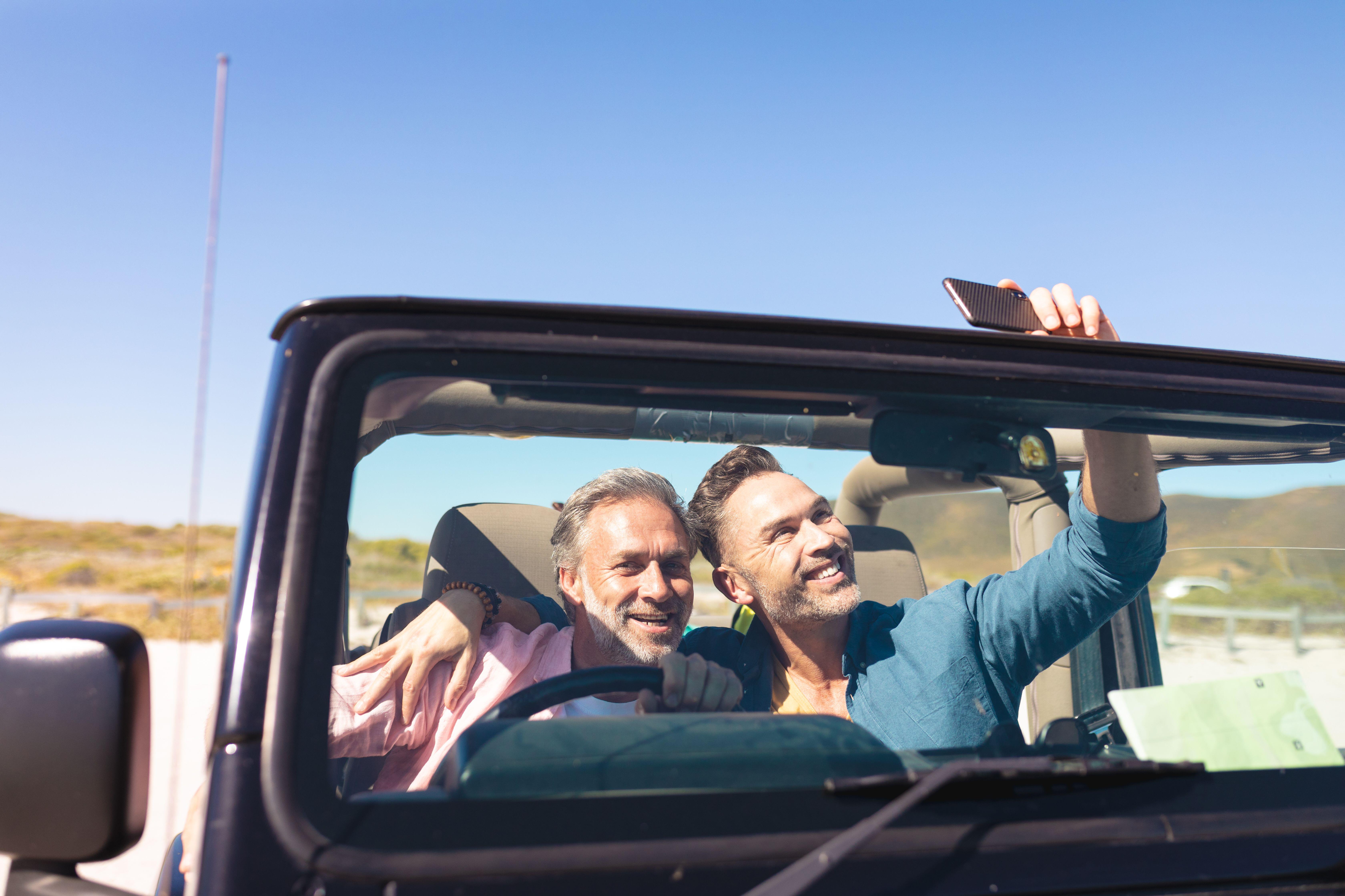 two men in a car taking a selfie