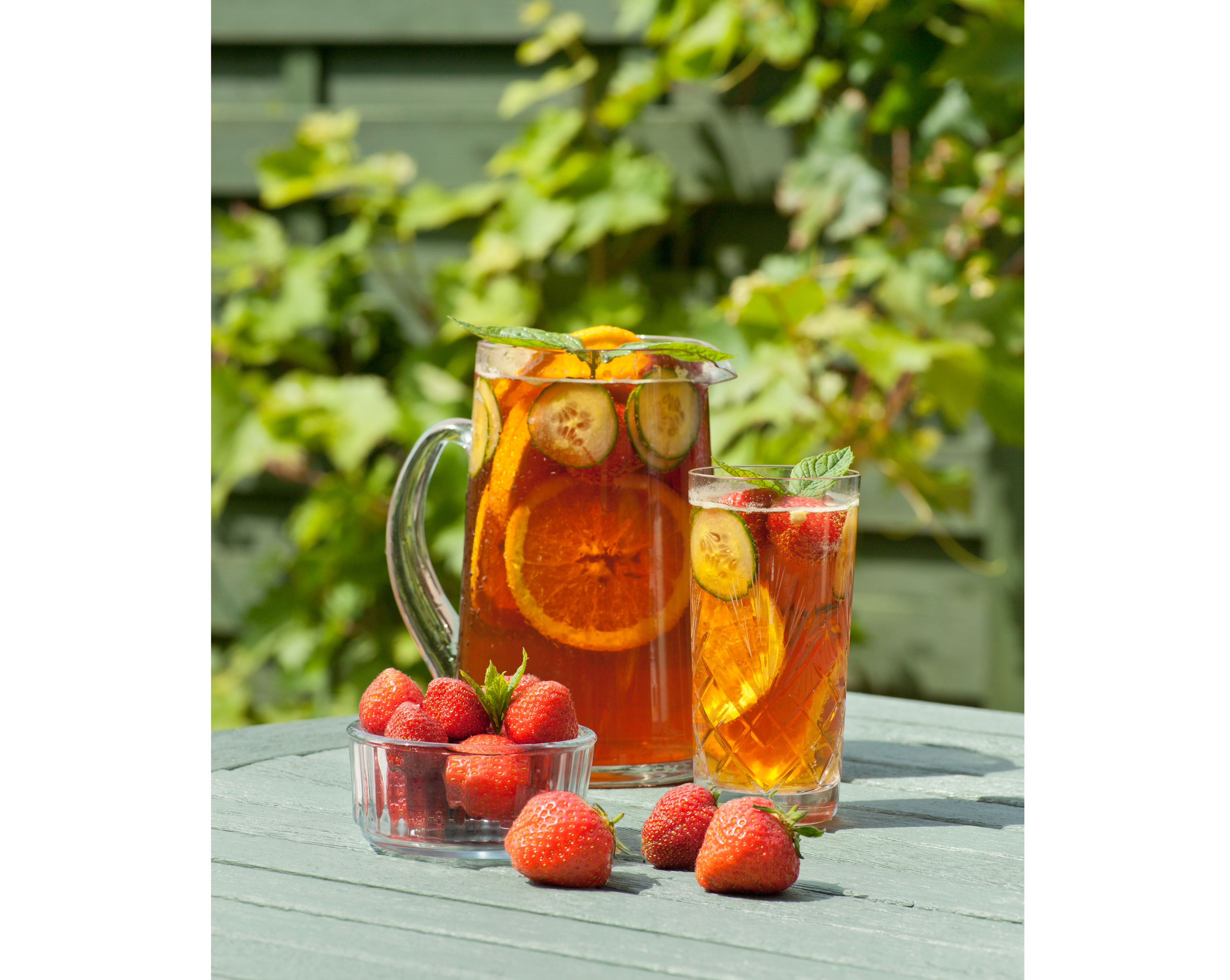 Jug of Pimm's and strawberries in garden