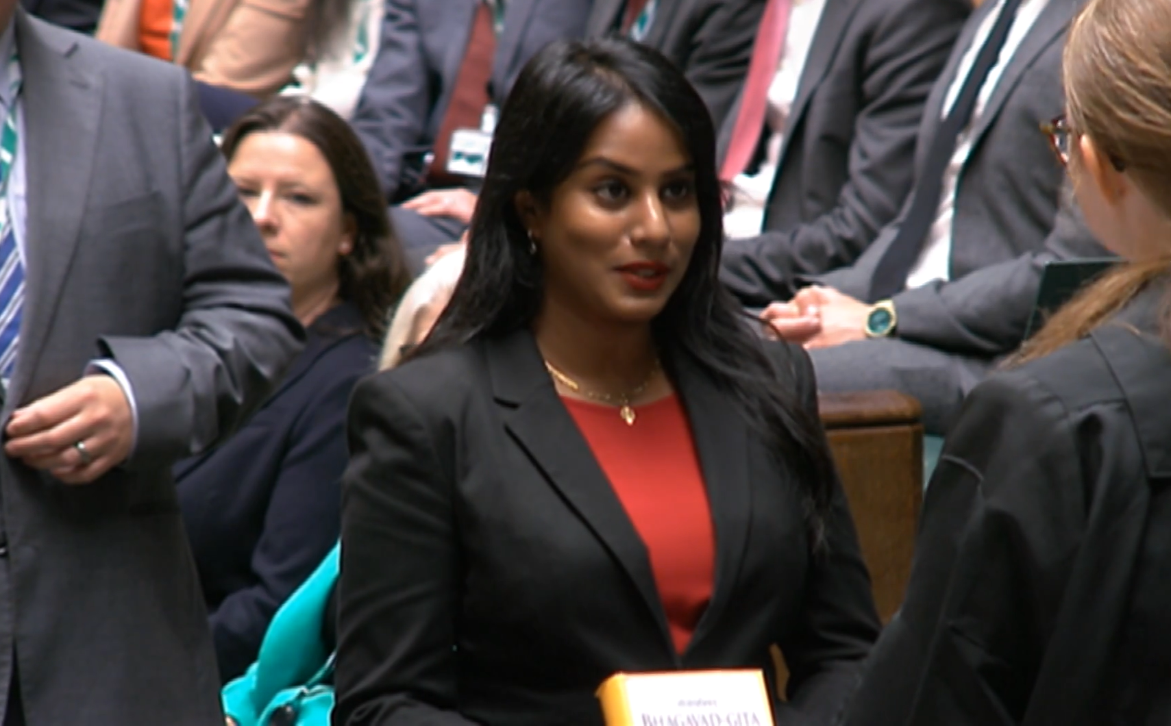 Labour MP Uma Kumaran holds the Bhagavad Gita as she swears in