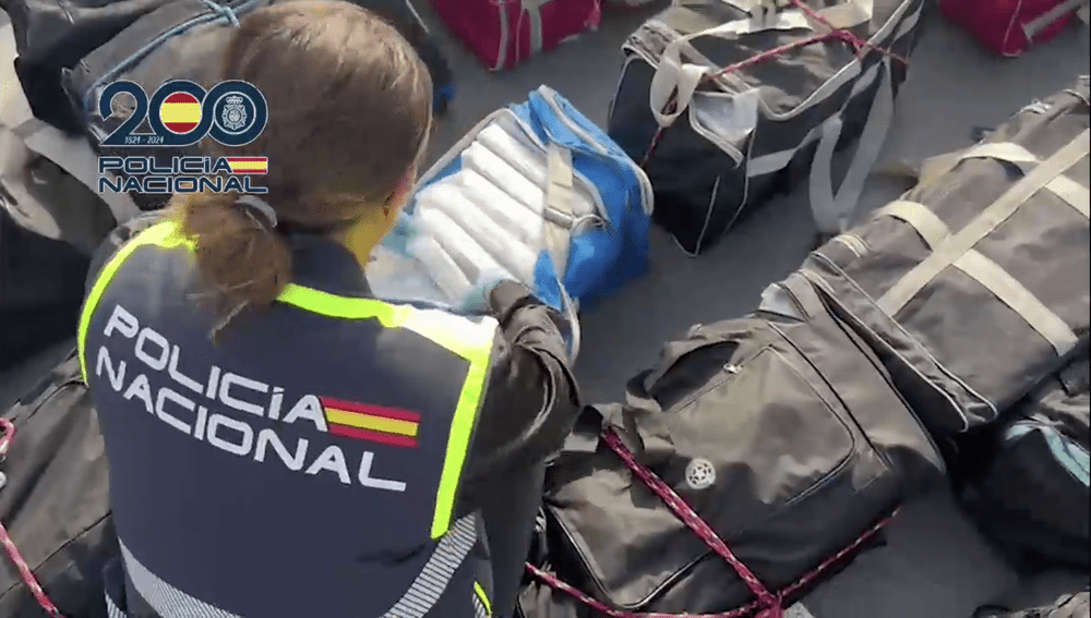 Spanish police officer inspects the contents of several holdalls