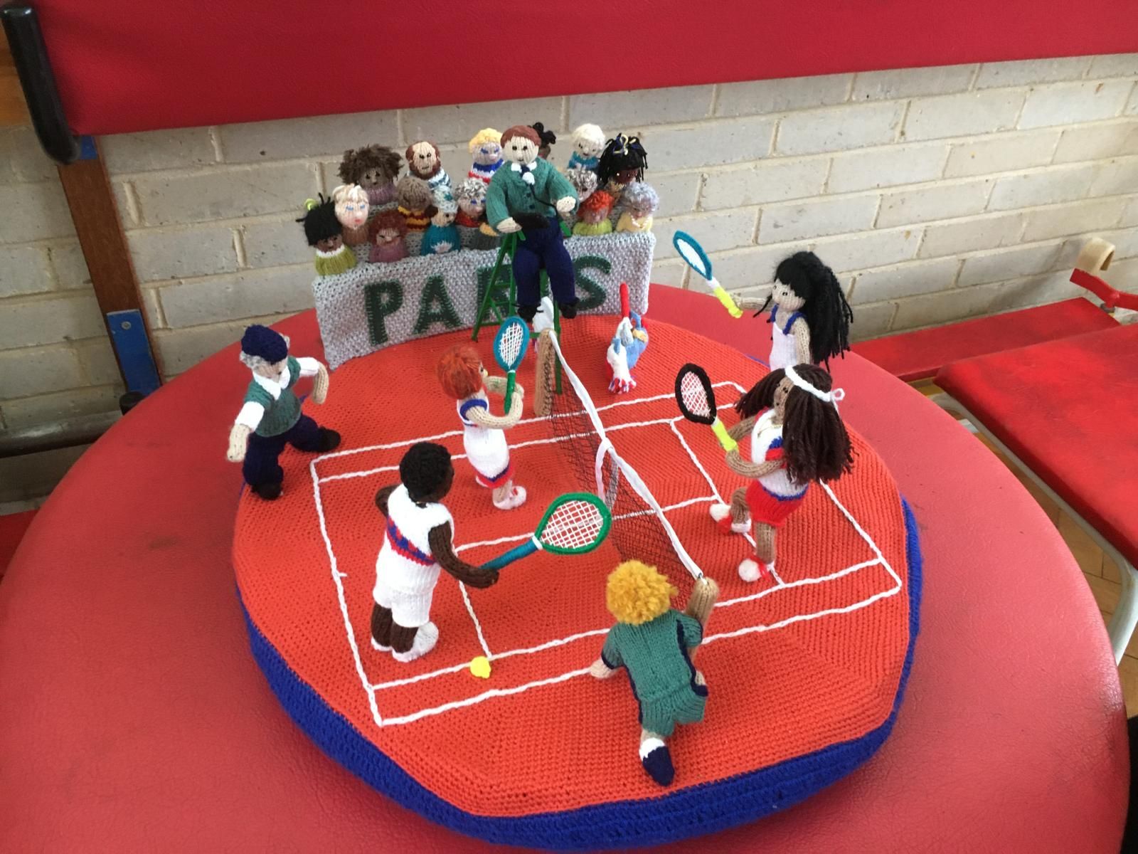 Yarn figures playing a sport with rackets 