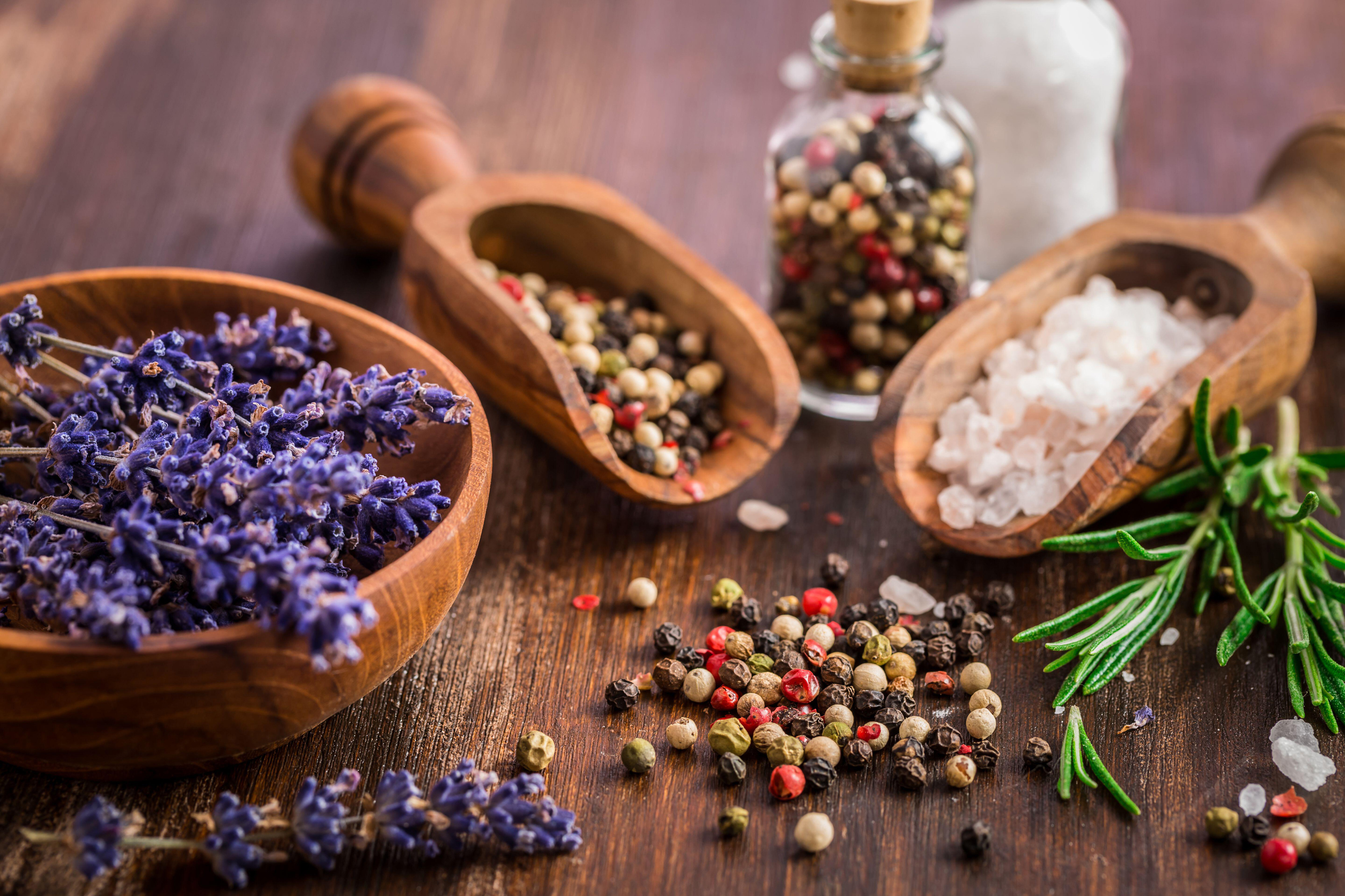 Salt, pepper, fresh rosemary and lavender on wooden background