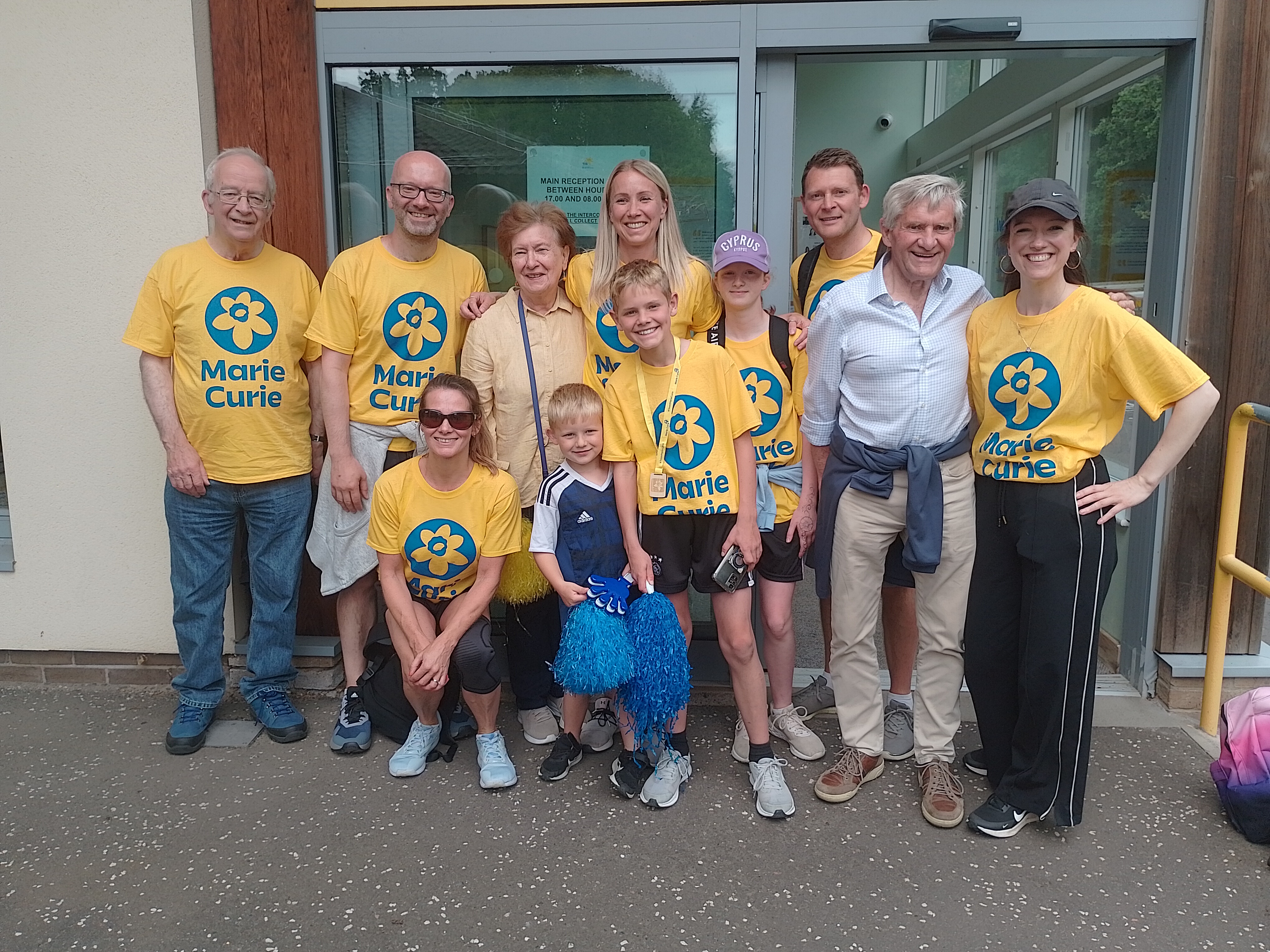 Archie surrounded by wellwishers, many in yellow Marie Curie T-shirts, after completing his charity challenge