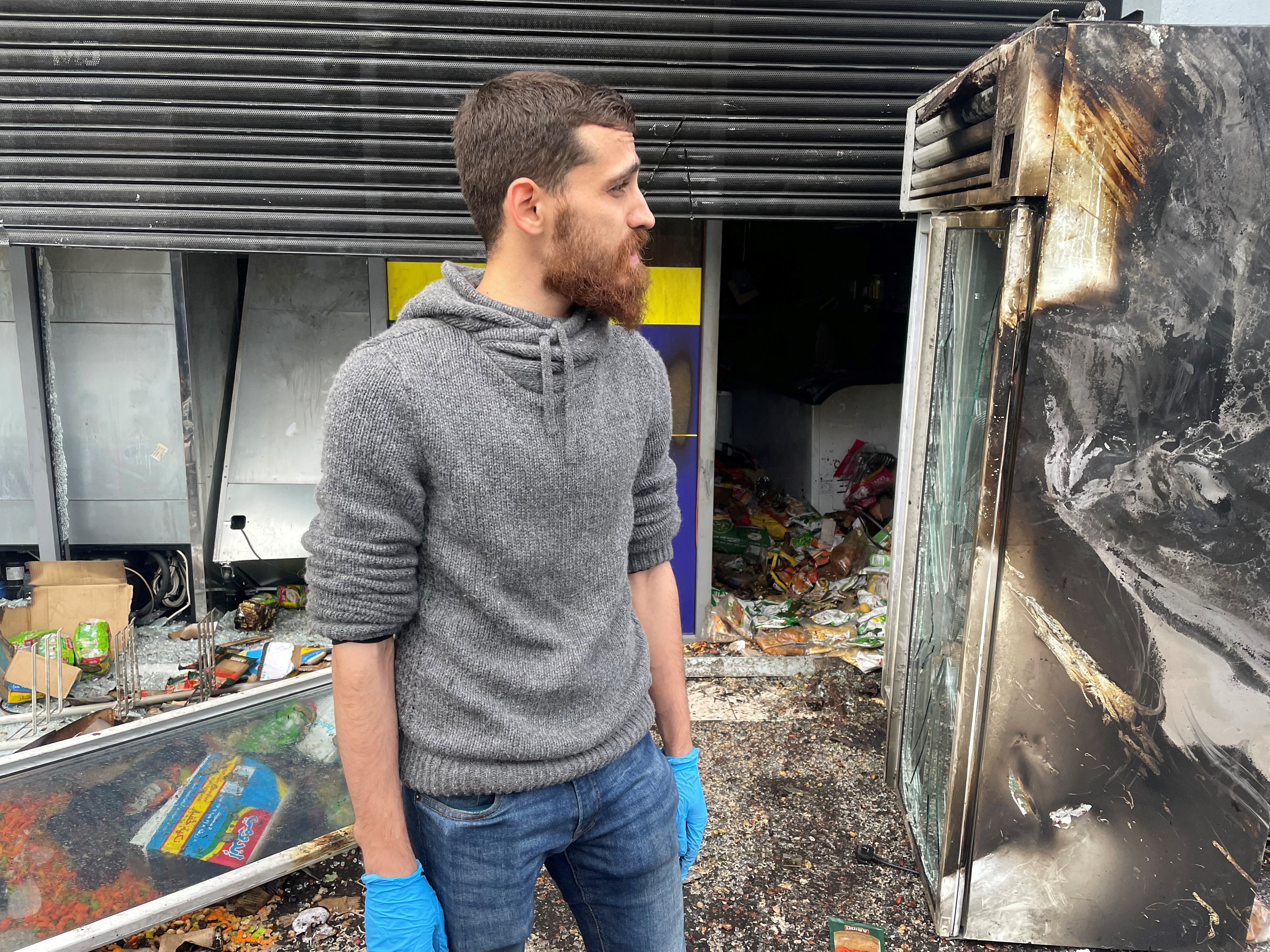 Bashir amongst the burnt-out remains of a shop