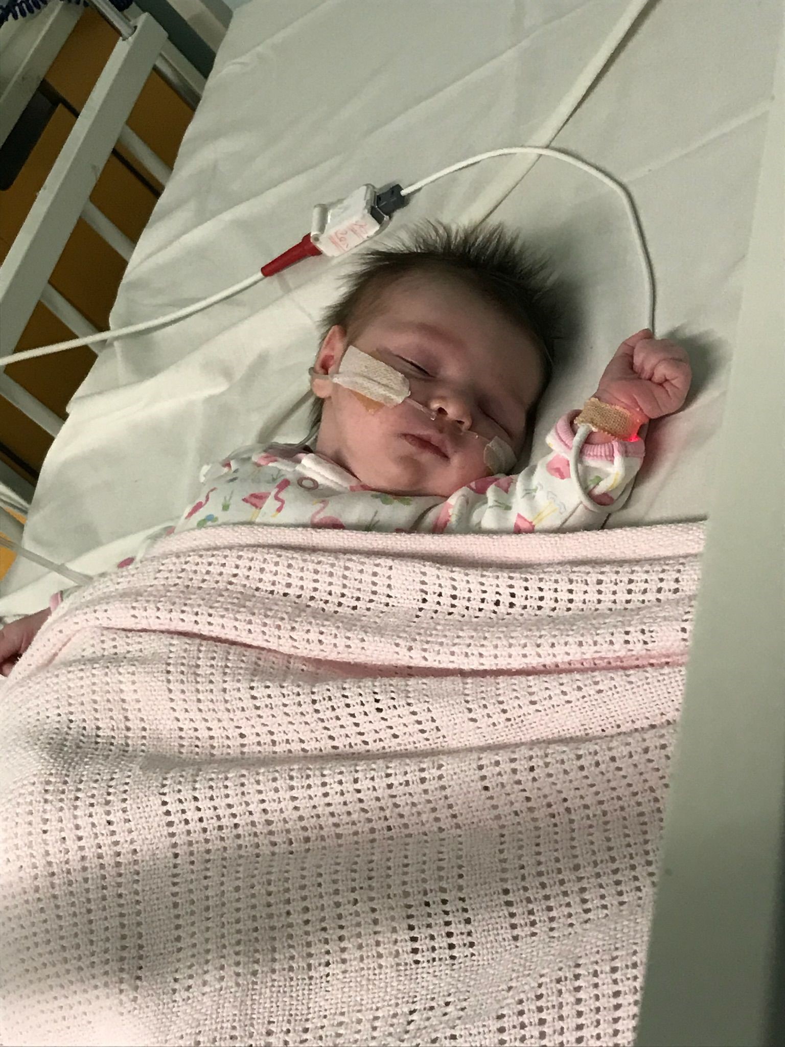 Baby Aria lying in a cot with a breathing tube