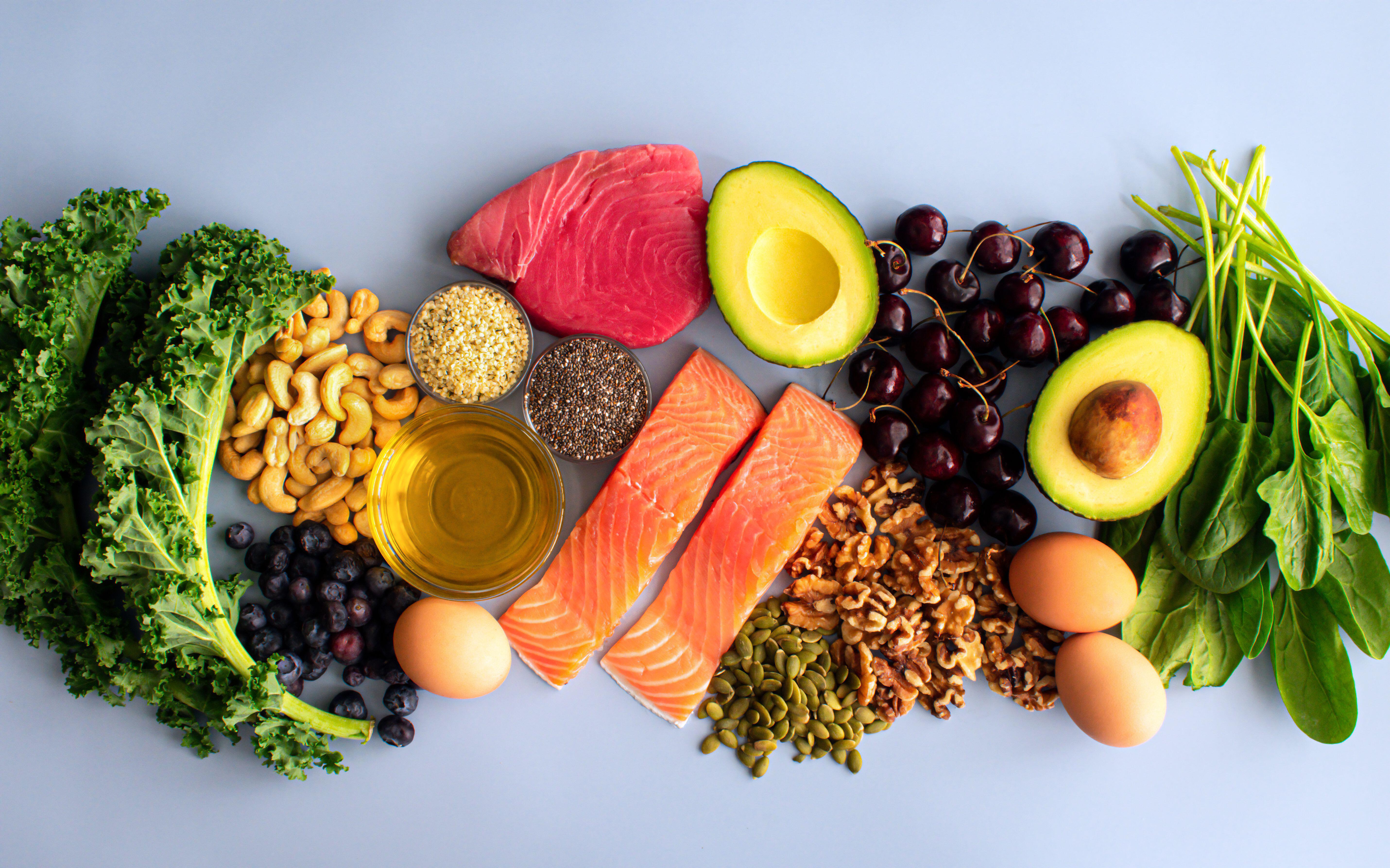 Overhead view of fresh omega-3 rich foods including fish, nuts, seeds, fruit and vegetables