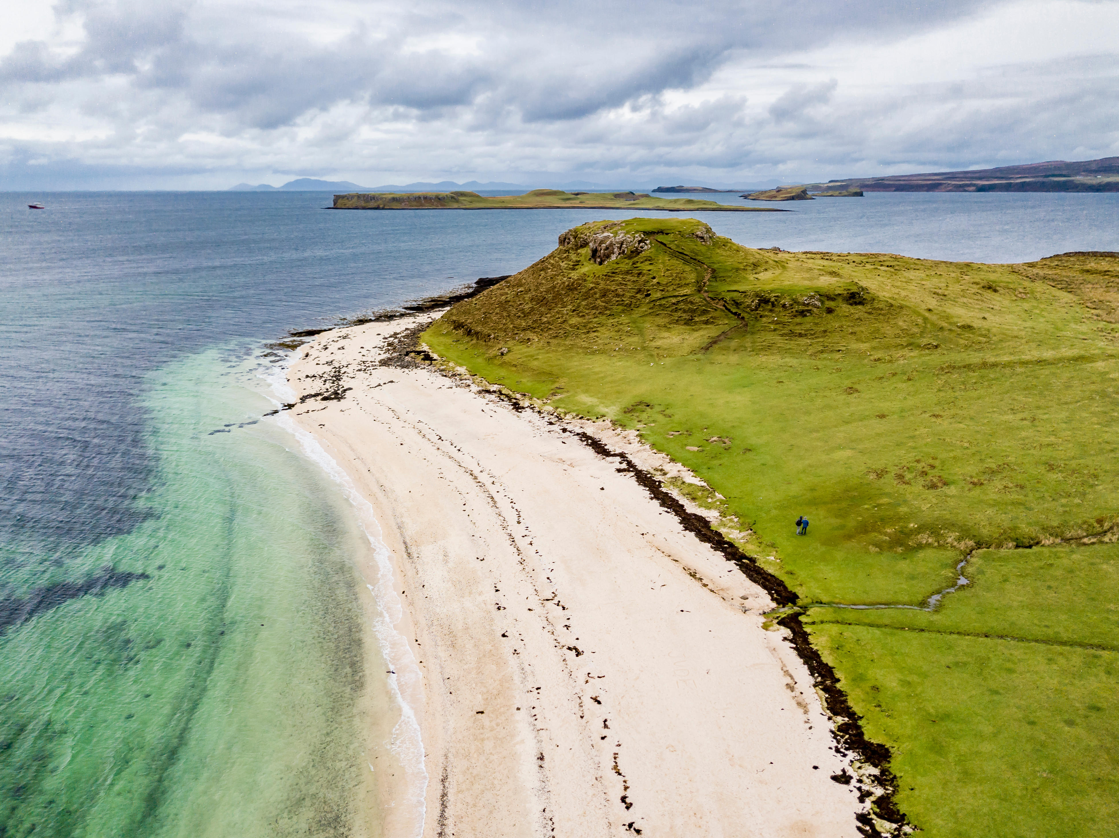 Aerial of the white sand and green grass at Clagain Coral Beach on the Isle of Skye - Scotland.