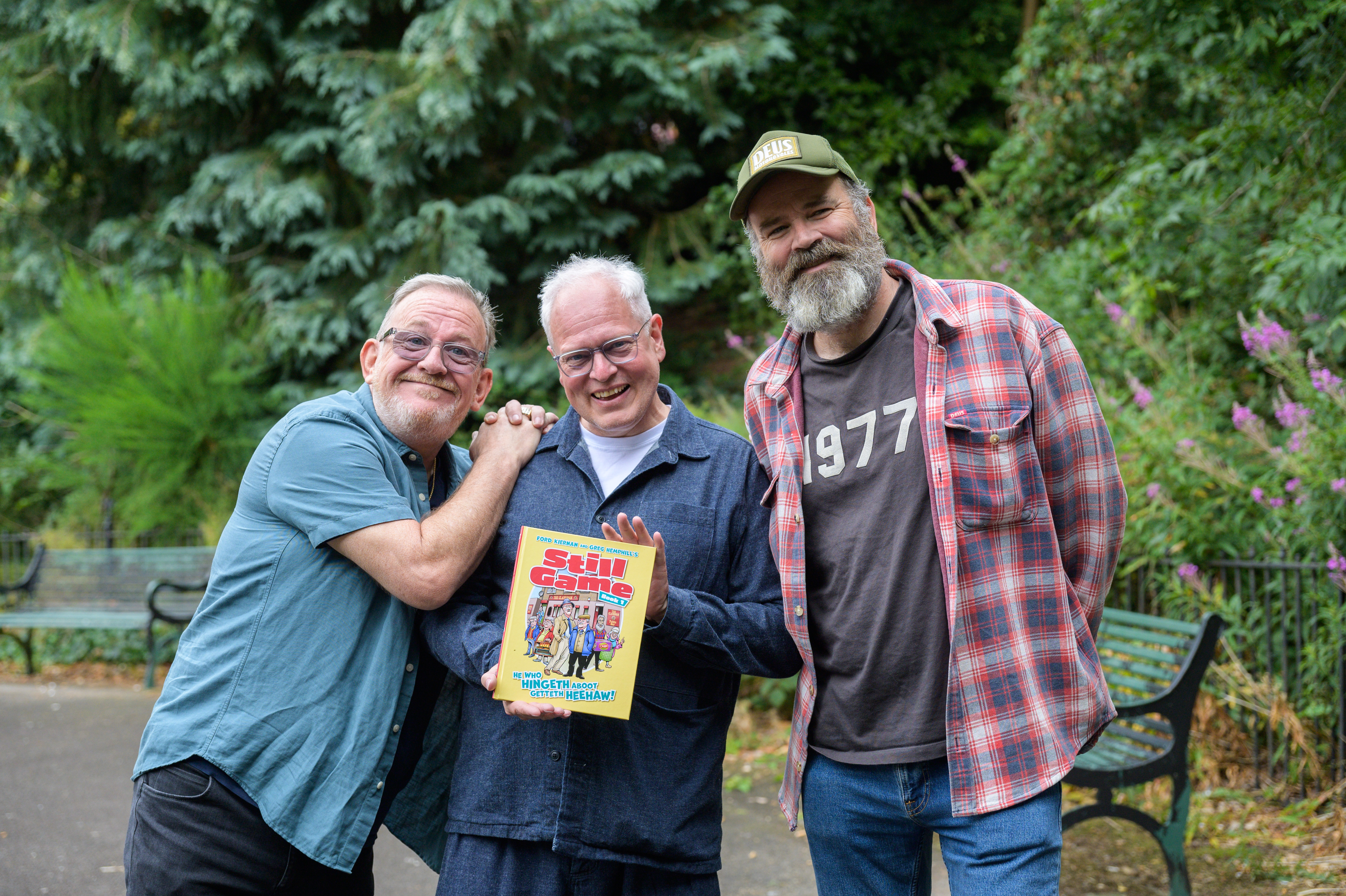 Ford Kiernan, Gordon Tait and Greg Hemphill pose with a copy of the book