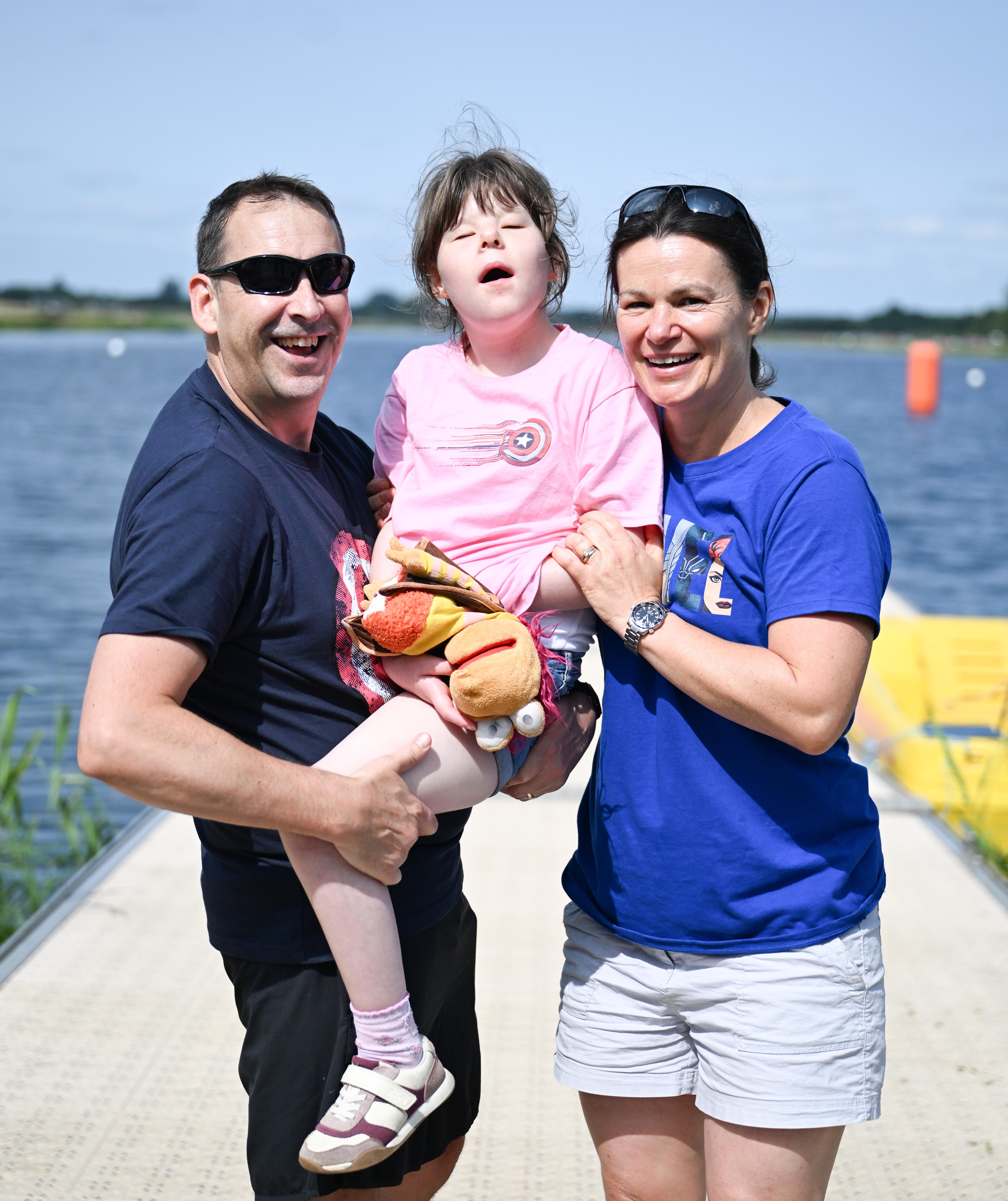 A man and woman holding their child