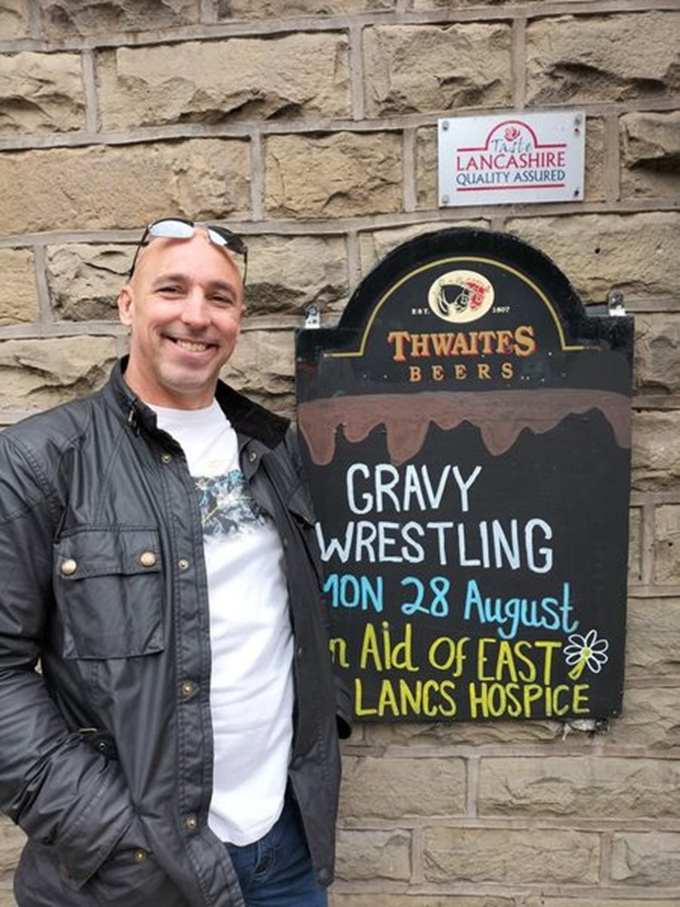 Man posing next to sign 