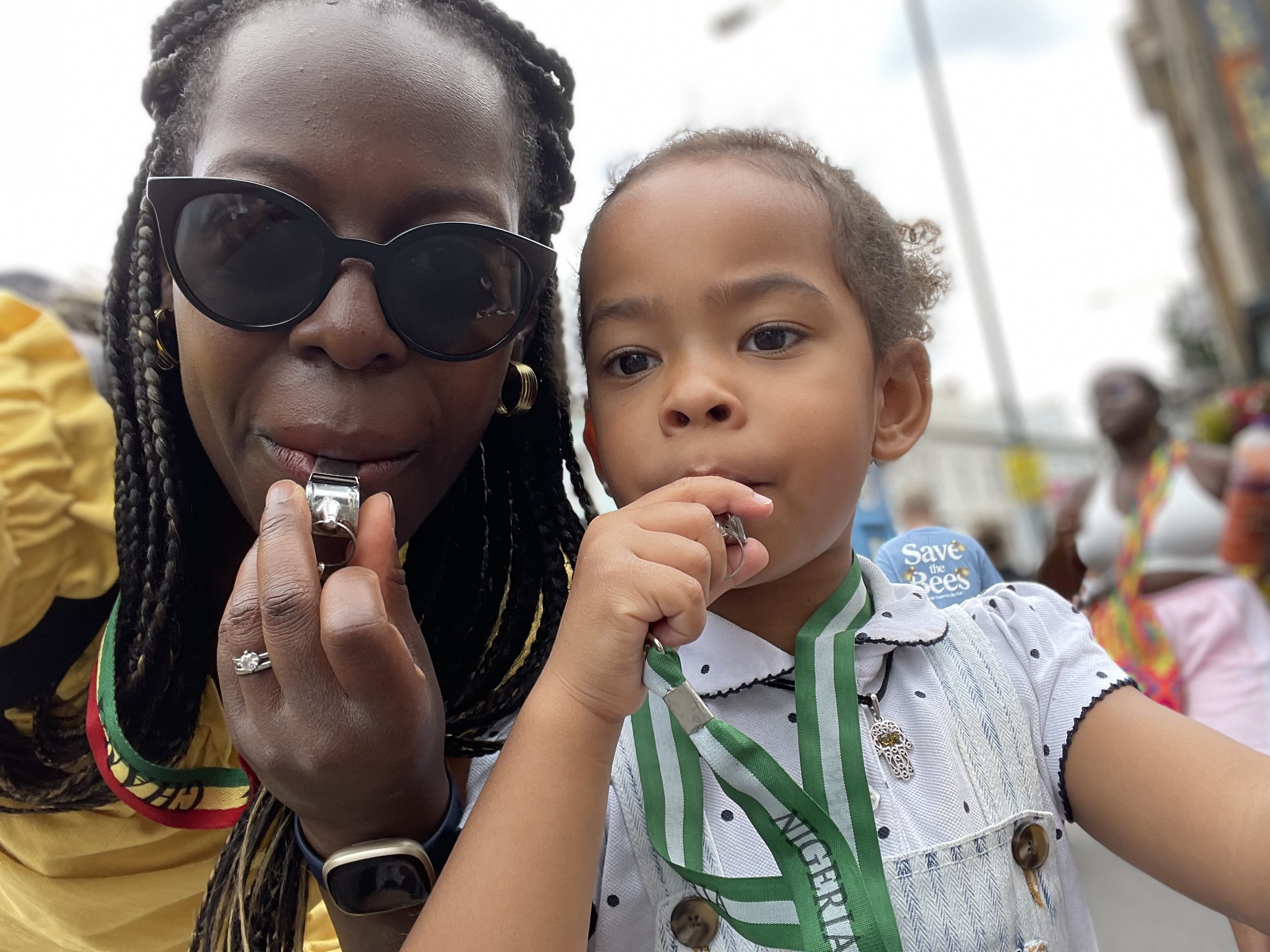 Woman and girl blowing whistles