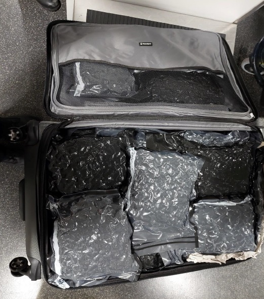 Cannabis vacuum packed in black plastic packed in a suitcase.