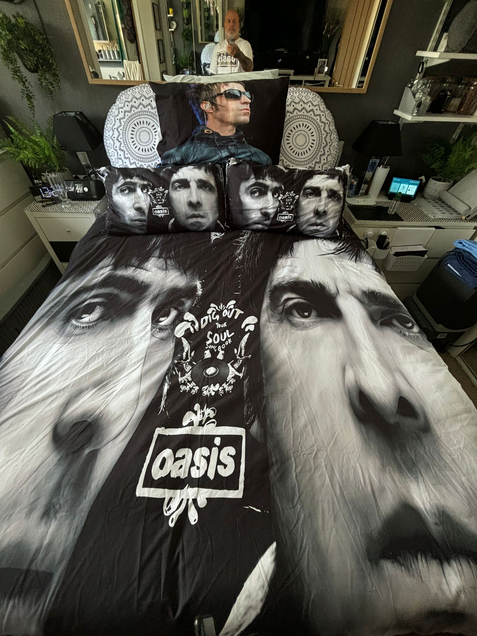 A top-down photo of duvet covers of Noel and Liam Gallagher's faces