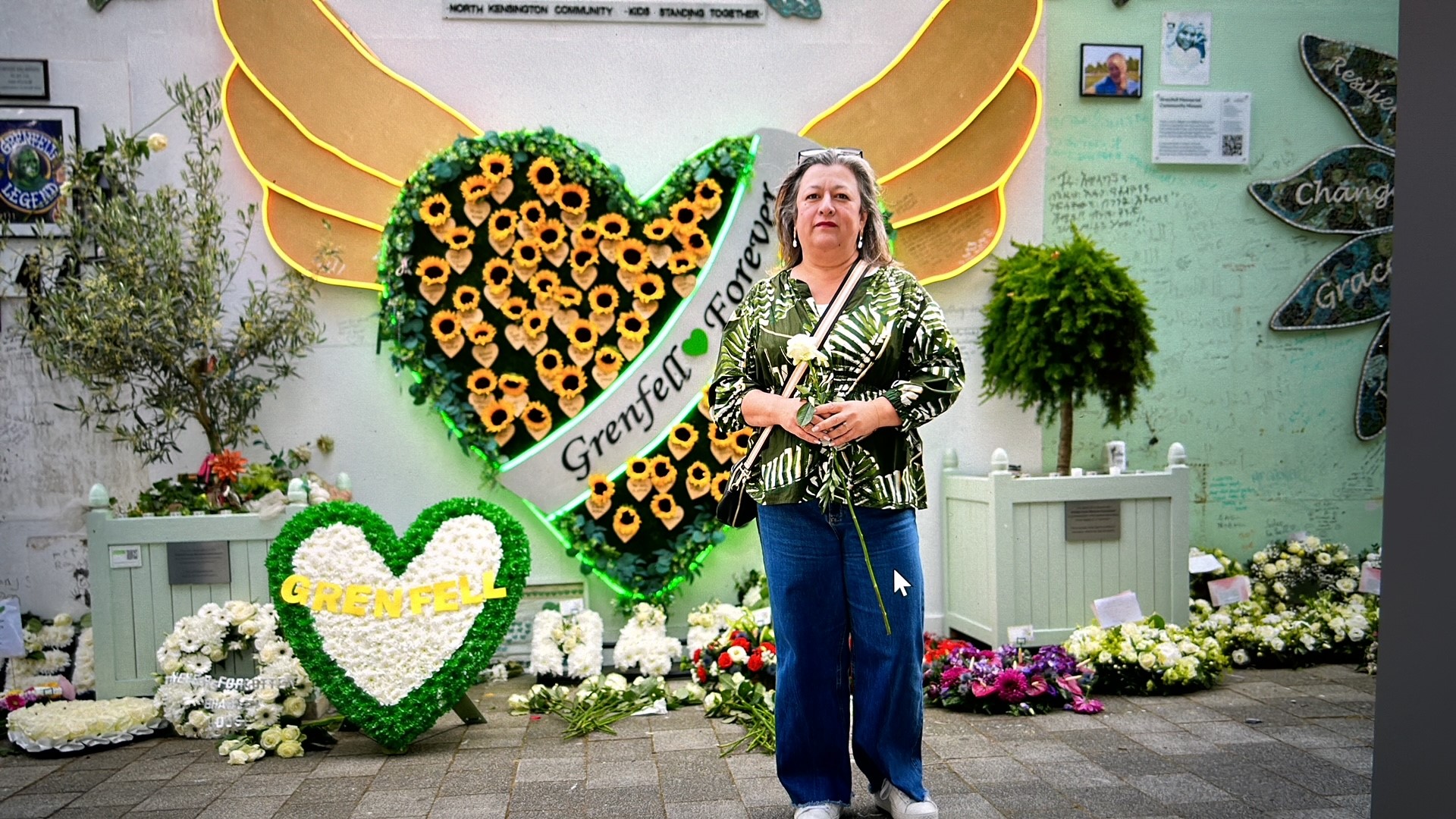 Sandra Ruiz stands in front of the Grenfell memorial wall 