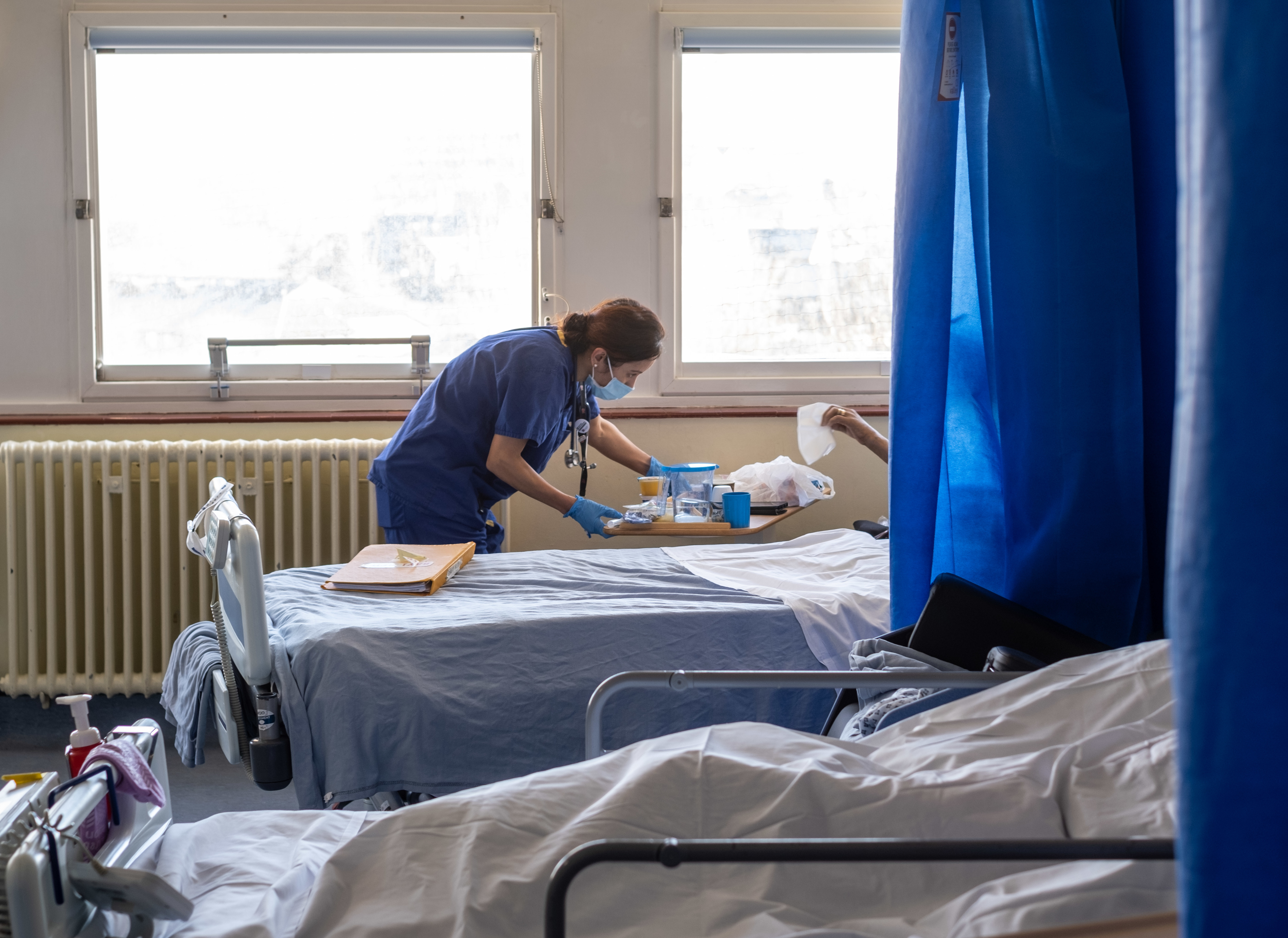 A nurse attending to a patient on a ward