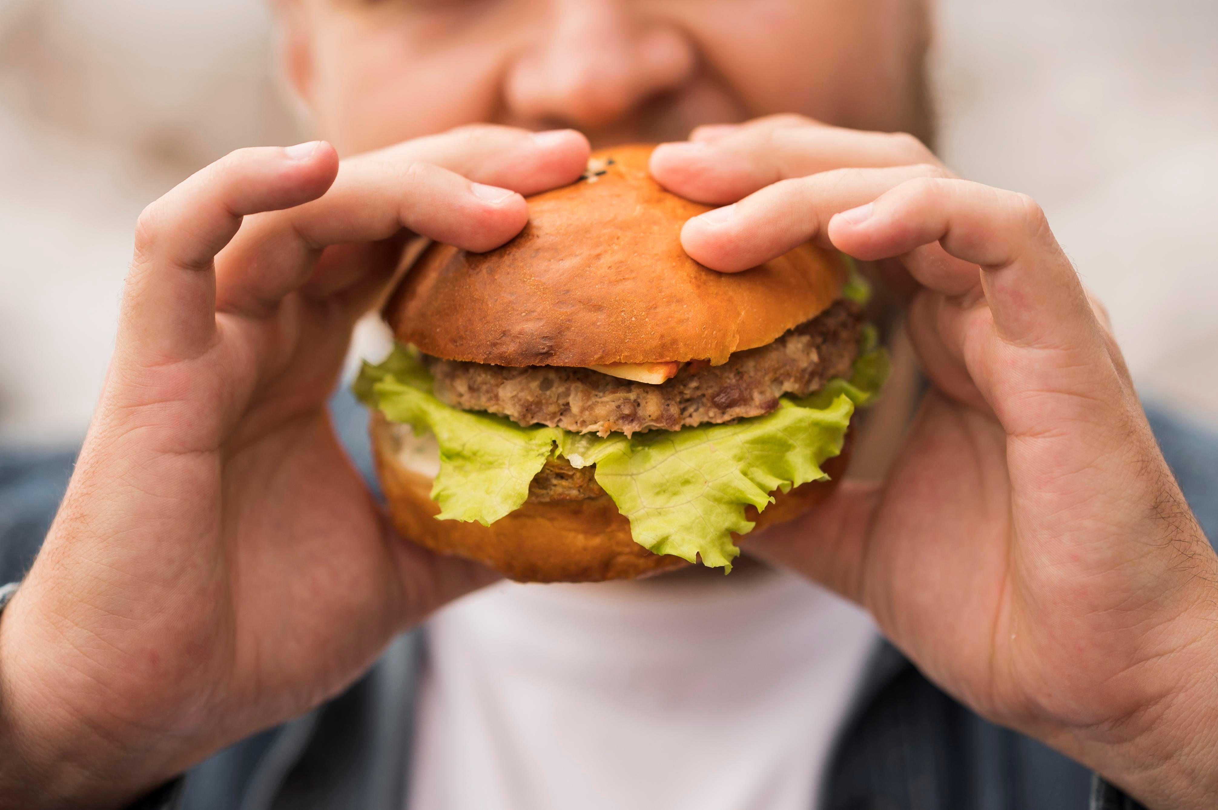 Close up photo of a man eating burger