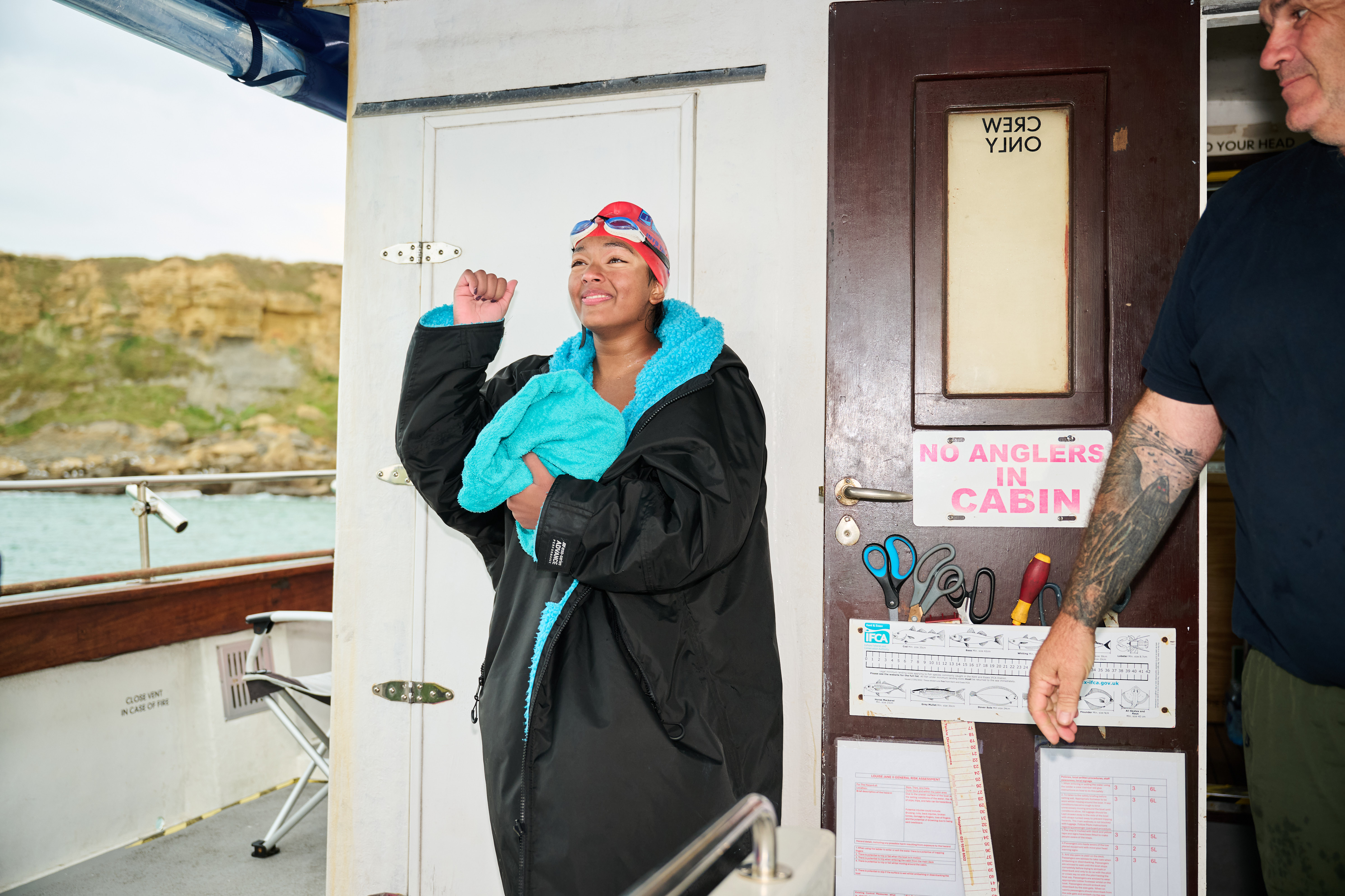 Prisha drying herself off while on a boat in the sea