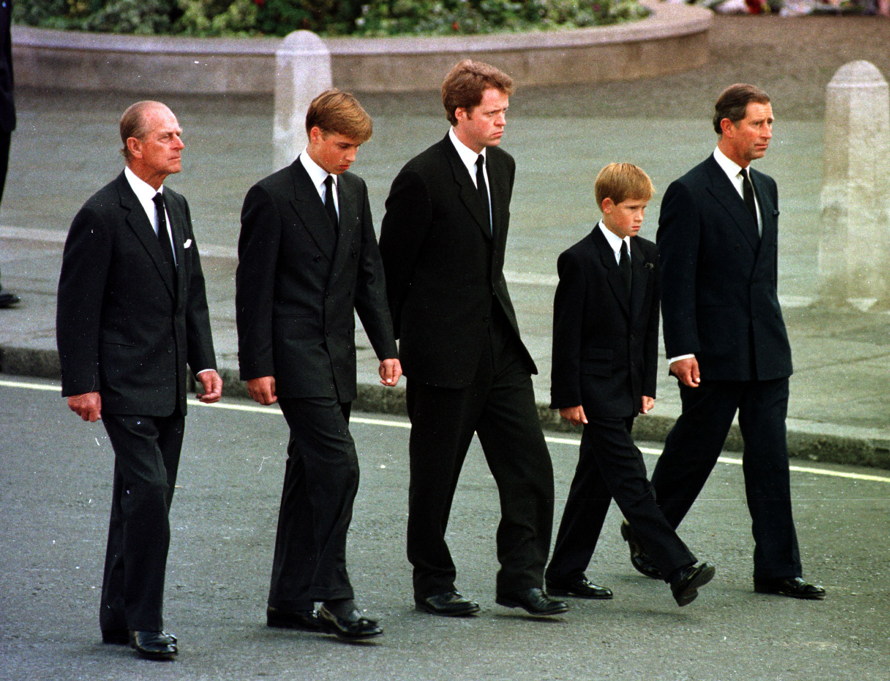 The then-Prince of Wales, Prince William, 12-year-old Prince Harry, Earl Spencer and the Duke of Edinburgh walking behind the coffin of Diana, Princess of Wales 