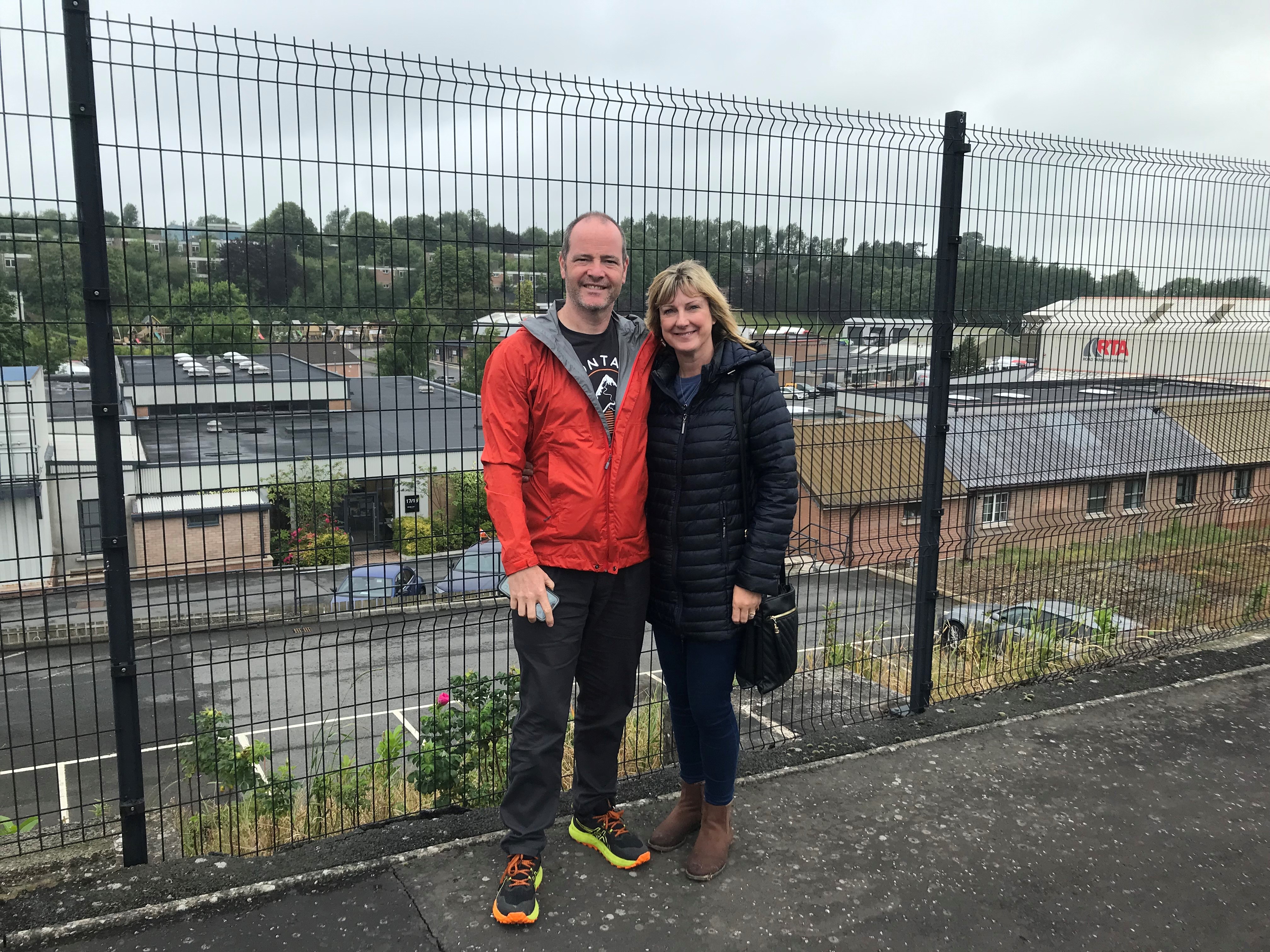 Rob Hughes and his wife Nicola smiling next to a fence