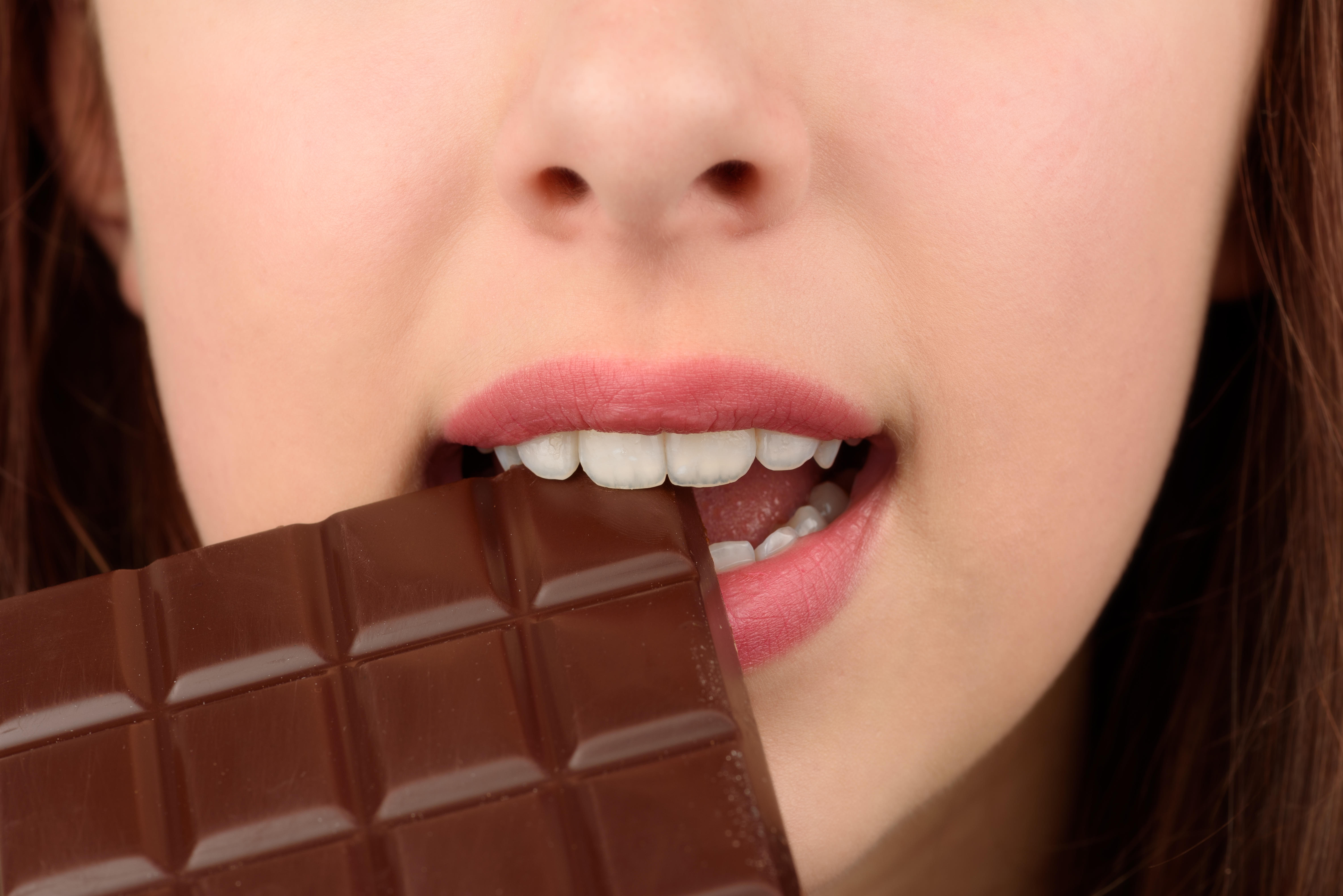 Close-up photo of woman eating chocolate