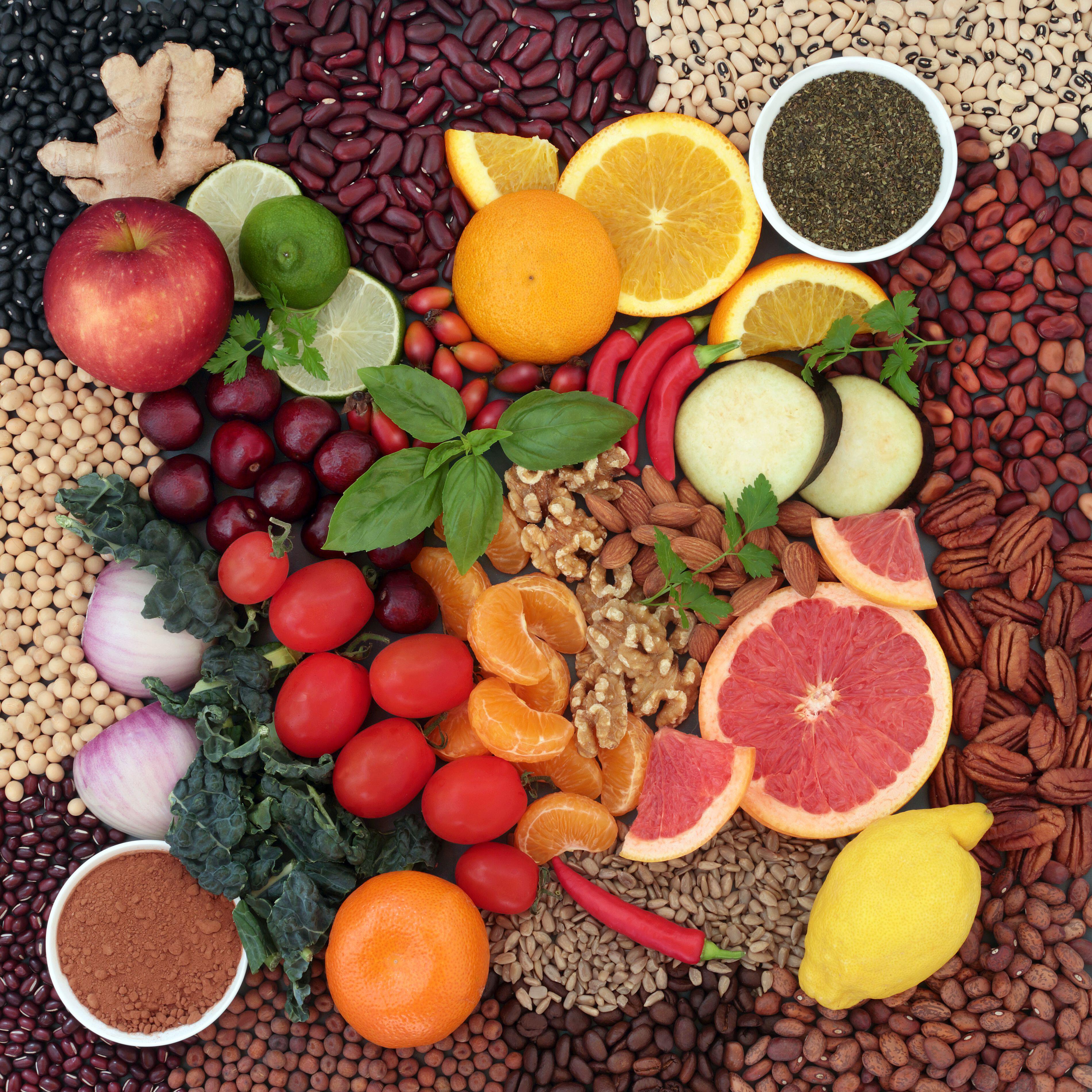 A table full of citrus fruits, nuts, seeds and berries 