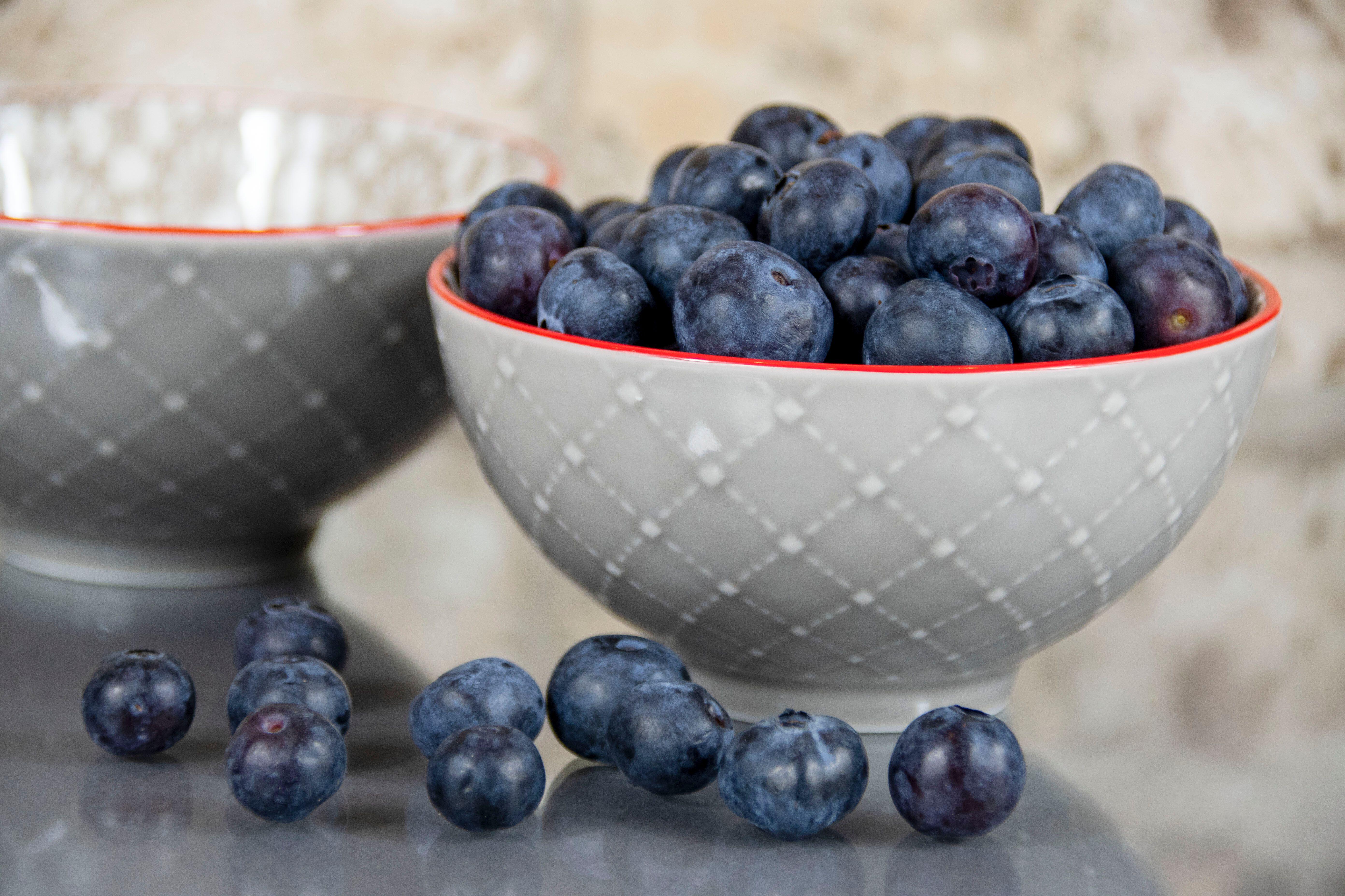 Fresh Blueberries in a bowl with a selection of loose berries in front