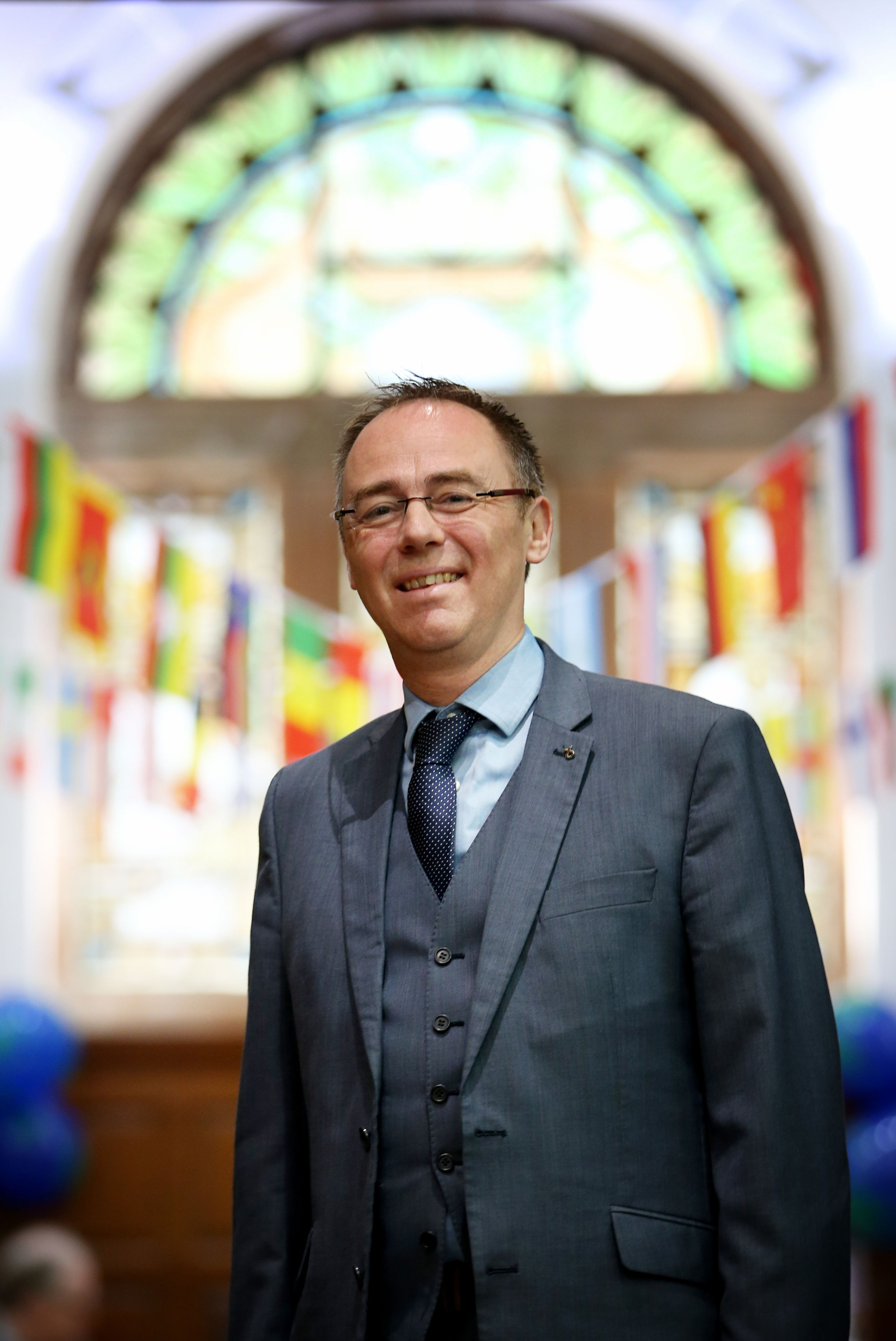 Climate action minister Alasdair Allan, wearing a blue suit, smiles at the camera