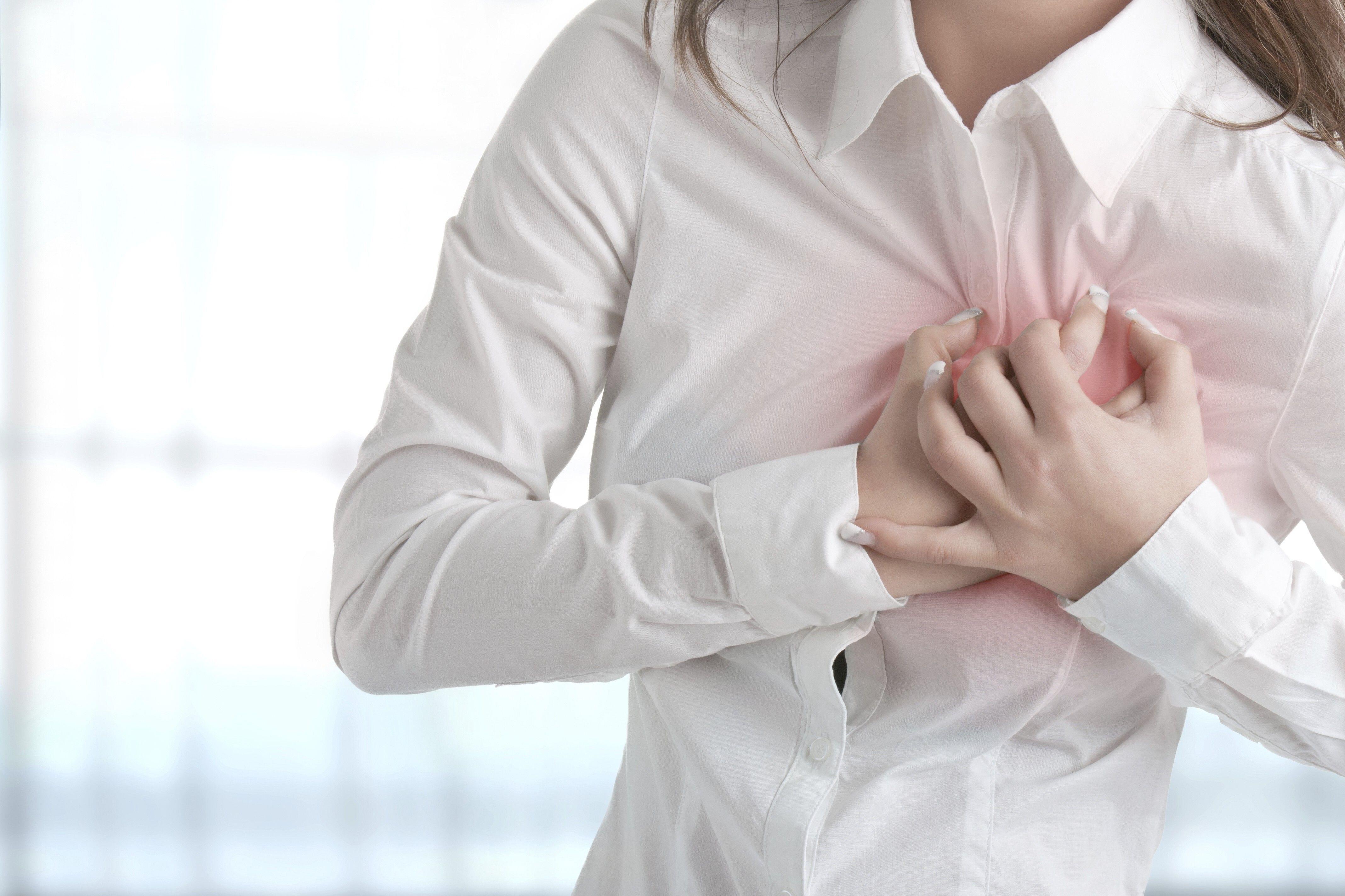 Cropped picture of a woman experiencing heart pains clutching her chest