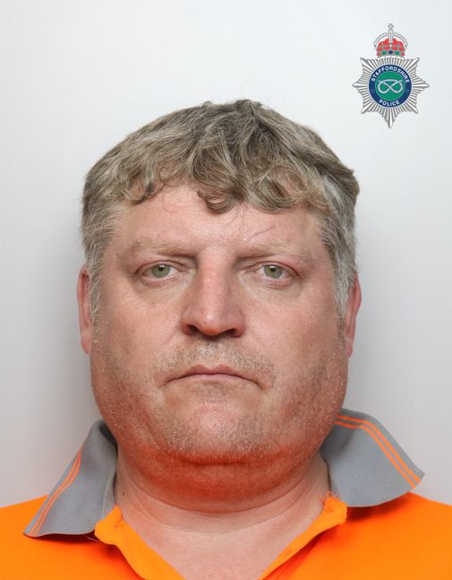 Head shot of a man with an orange shirt