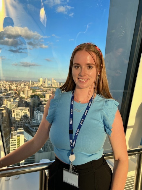 Jamilla Blake standing by a window overlooking a city