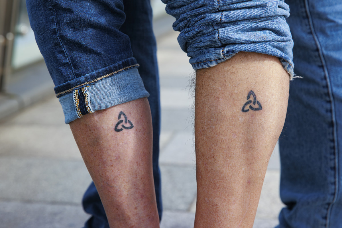 Angela Harsanyi and Gian Perroni show off their matching Trinity tattoos 