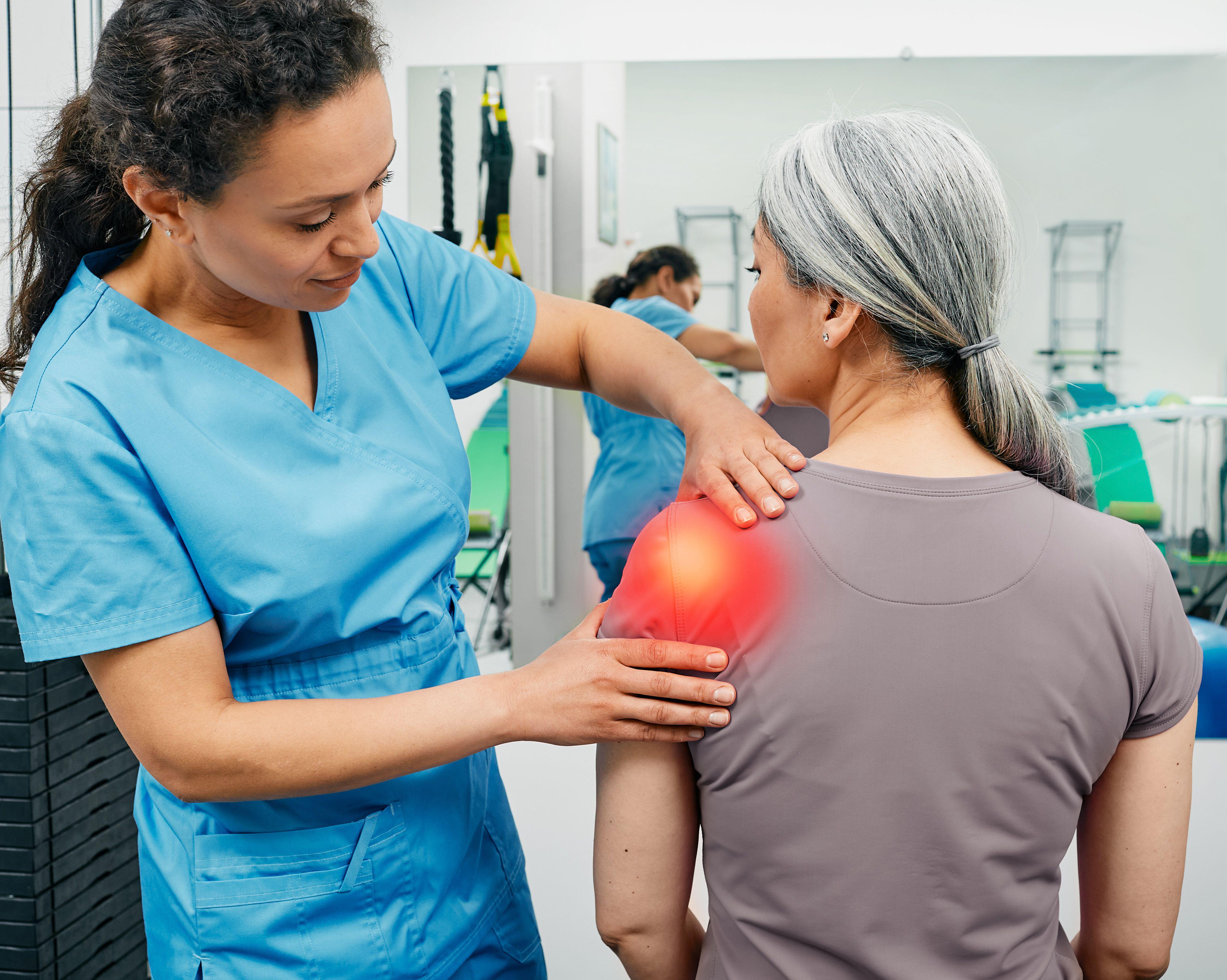 Physiotherapist examining a woman's achy shoulder 