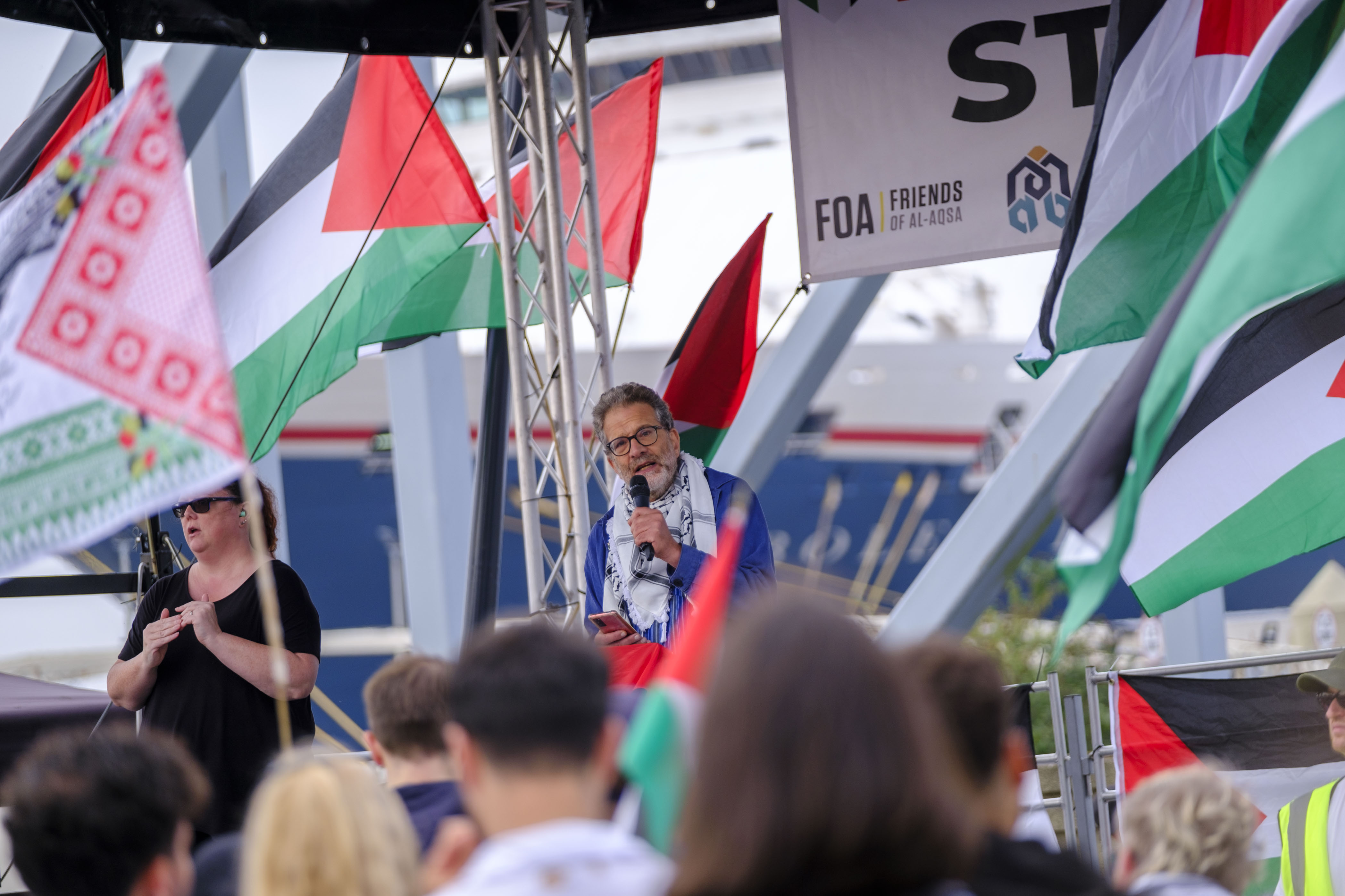 Man on stage speaking to people 