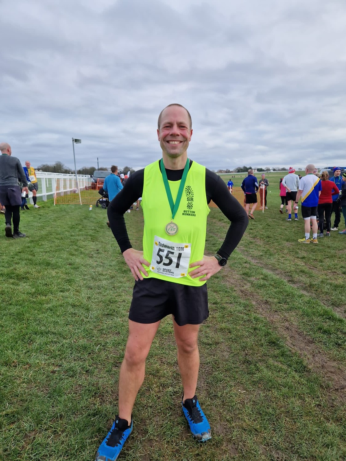 Darren Wood wearing a Sutton Runners vest with his medal for the Tadworth 10 run