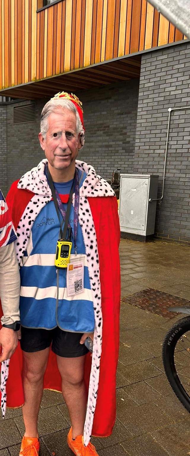 Darren Wood wearing a mask of King Charles III and a regal robe for parkrun on the coronation weekend