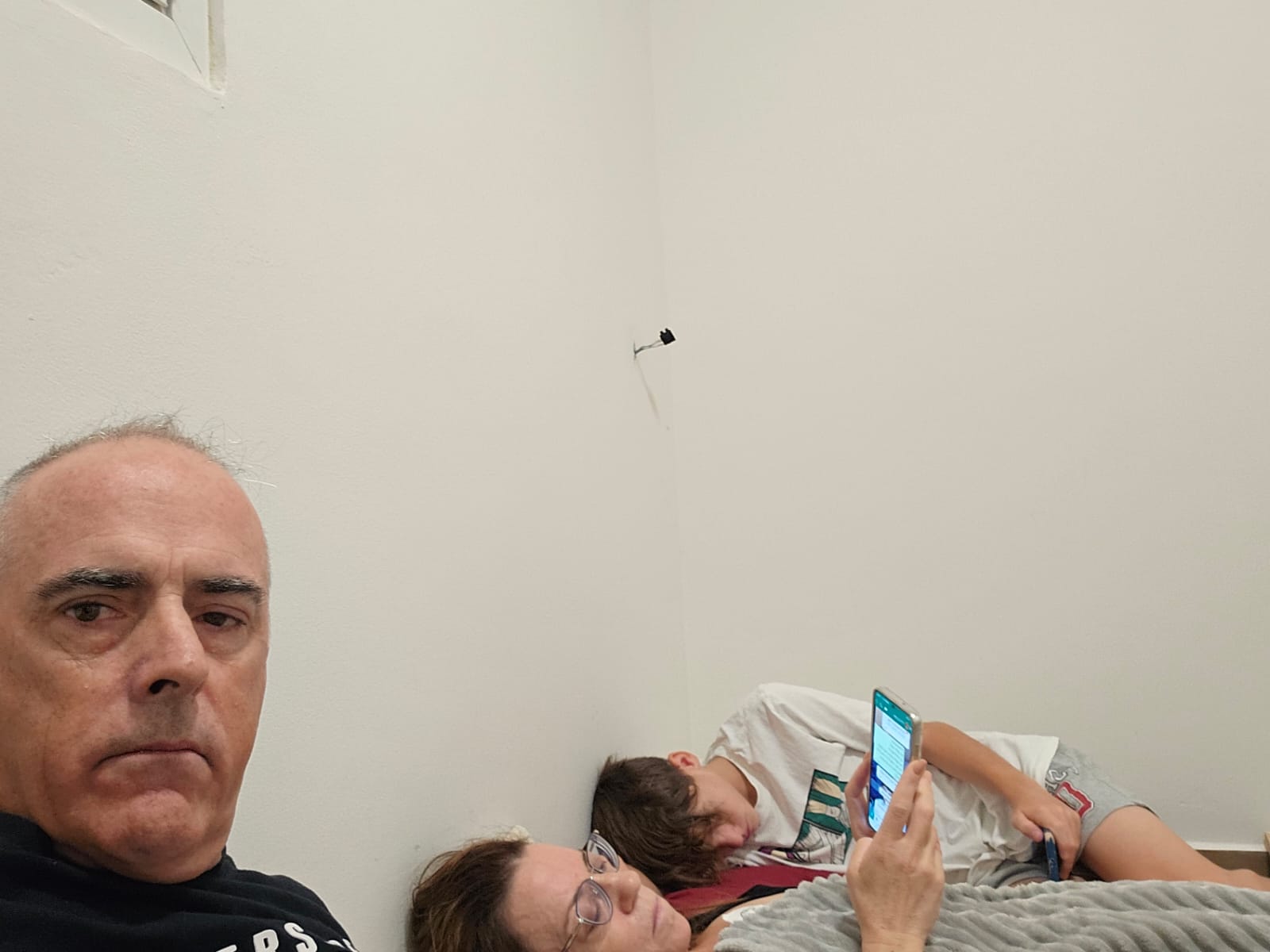 Man and his family on a bed on the floor in a safe room