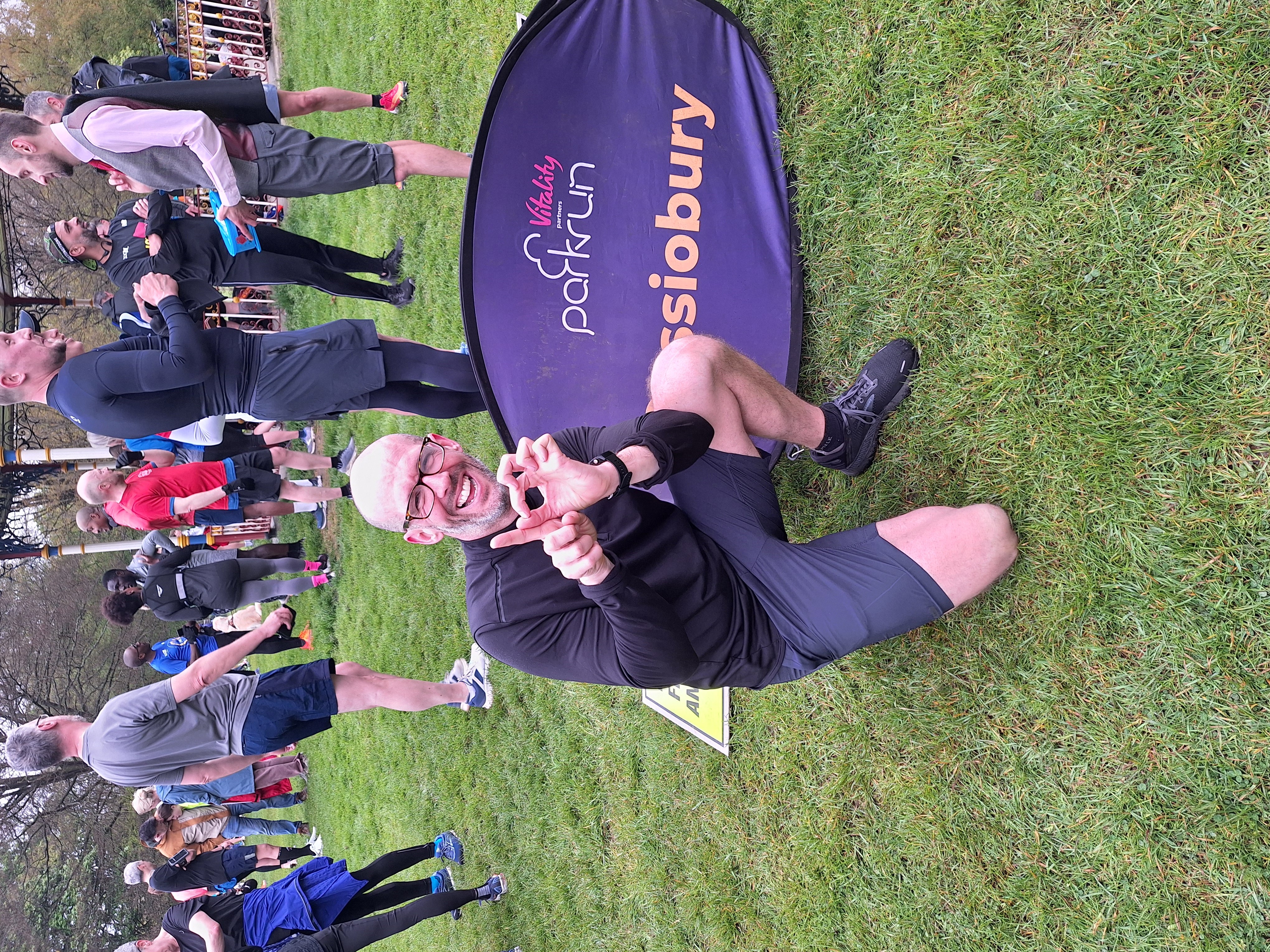 Patrick Fox making 100 with his hands at Cassiobury Park, Watford, for his 100th parkrun in April 2024