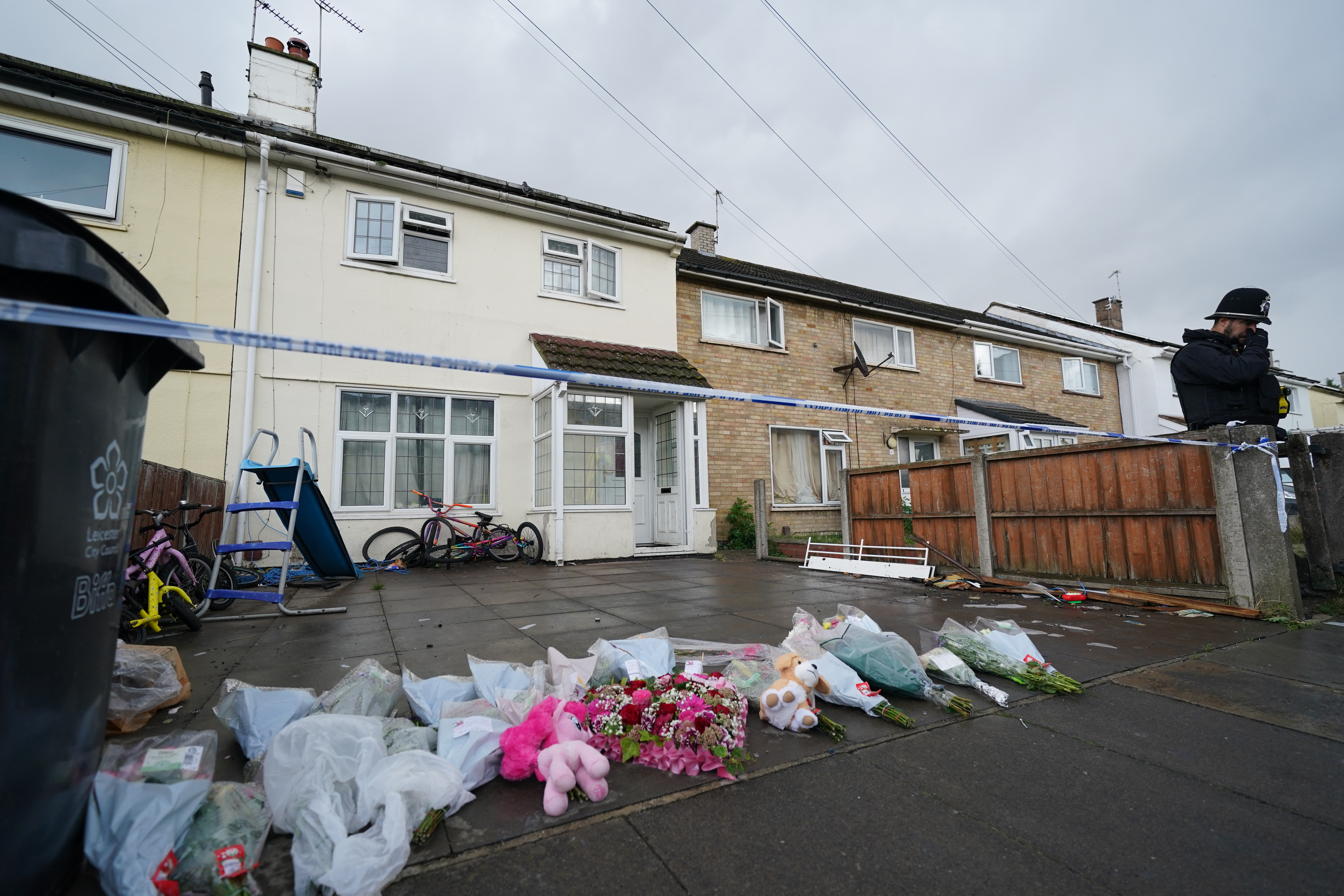 Flowers left outside a house taped off by police tape