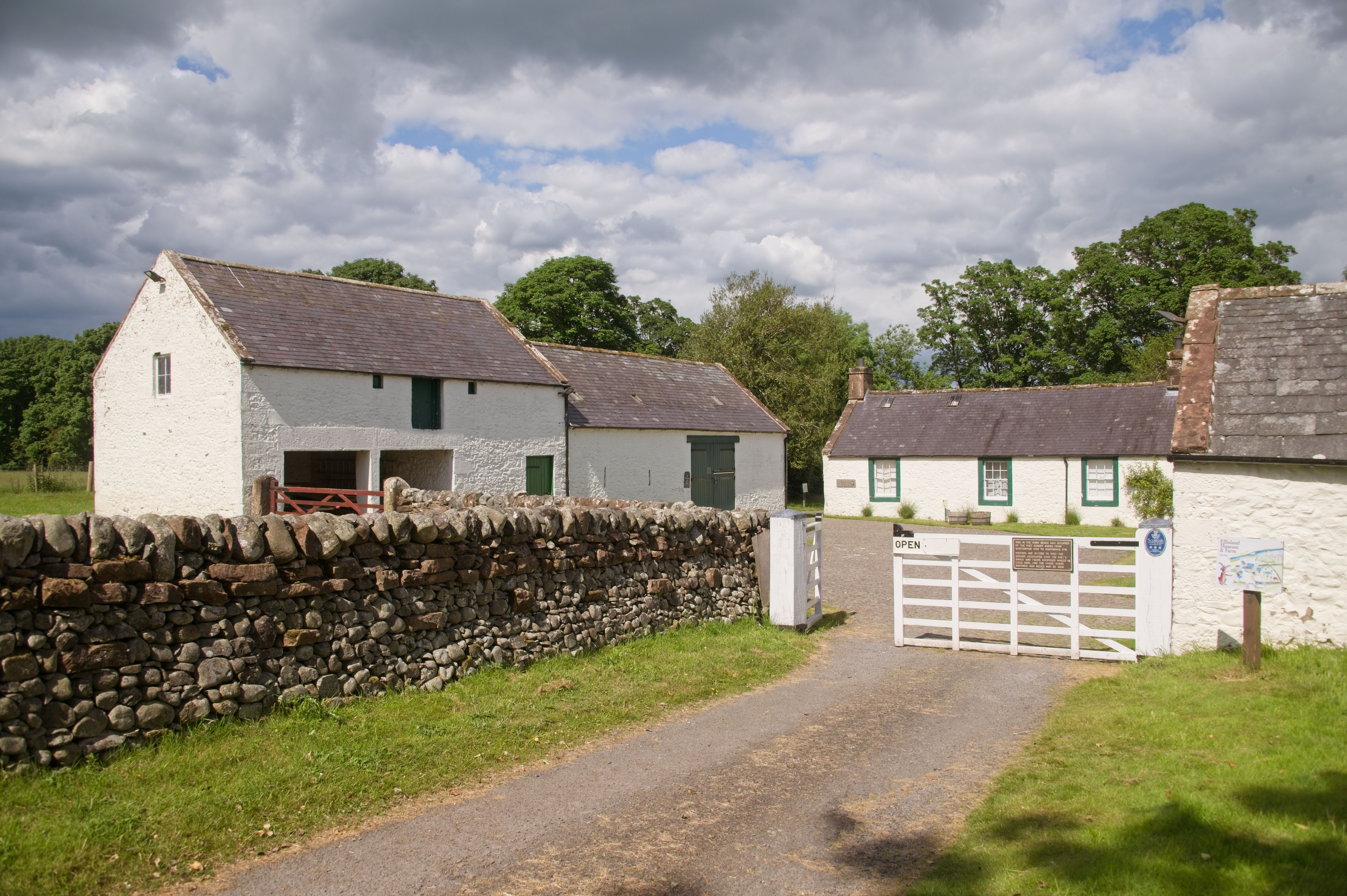 White farm buildings with green window frames