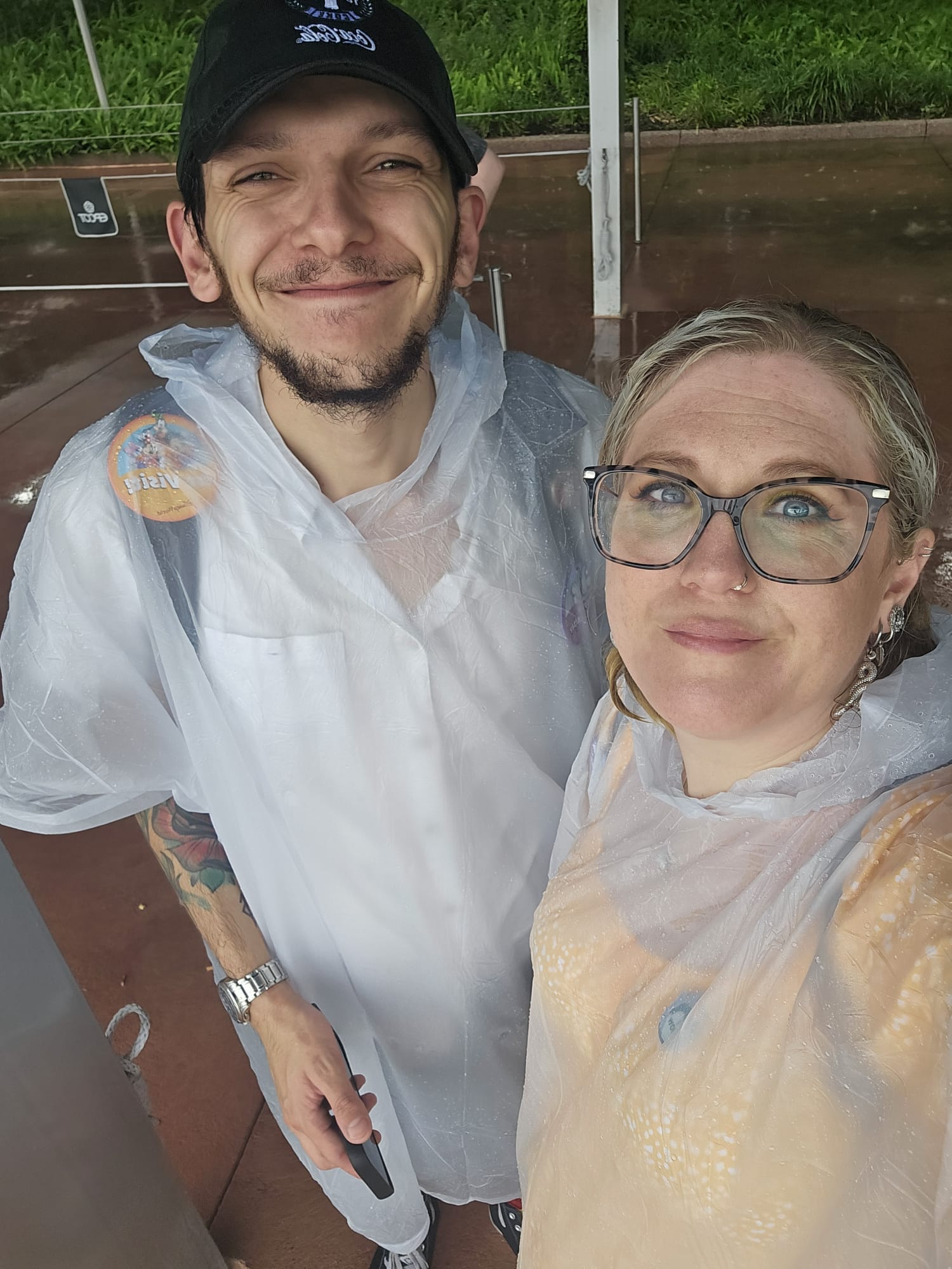 Couple at Disneyland Florida while wearing clear ponchos to protect themselves from rain brought on by Hurricane Milton