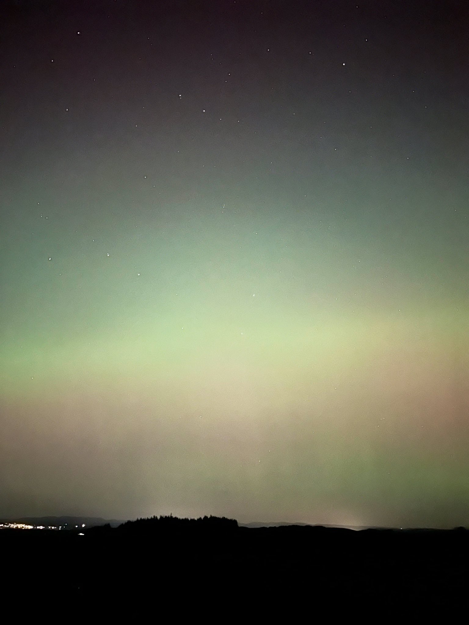 Green hues of the Northern Lights light up skies over Lancaster, England, UK