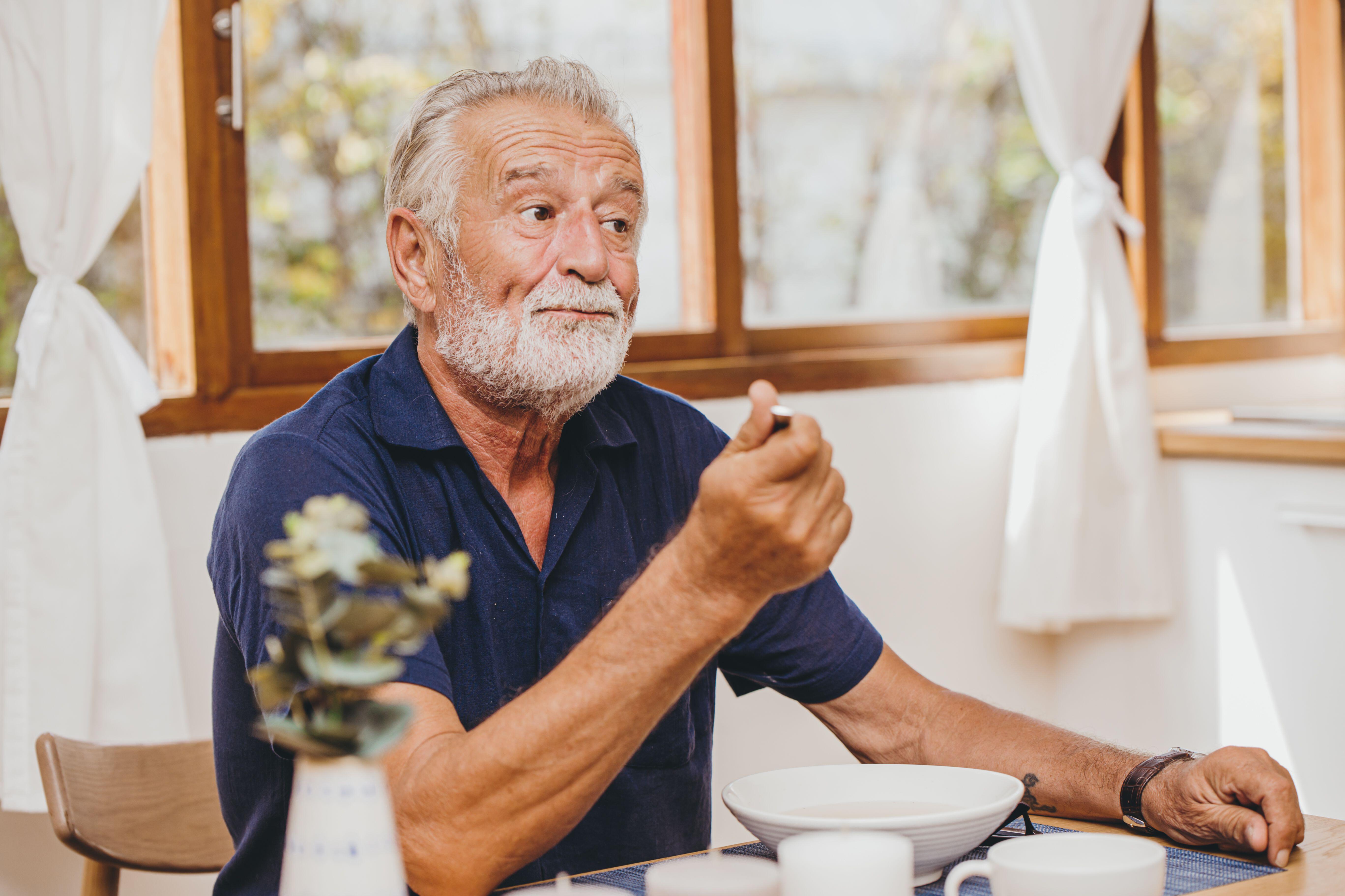 Elderly man sat at home not feeling hungry