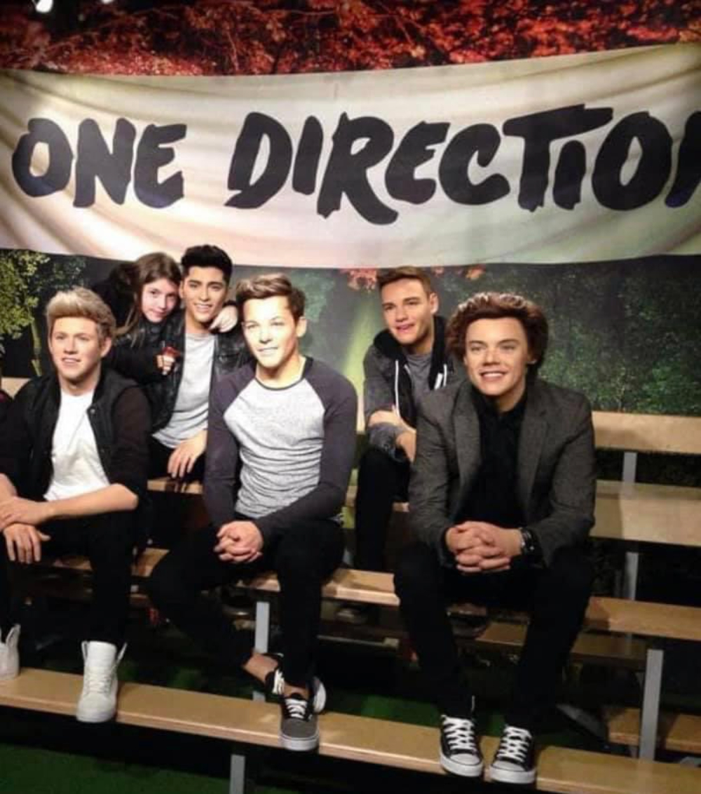 Young girl pictured with a wax work of One Direction