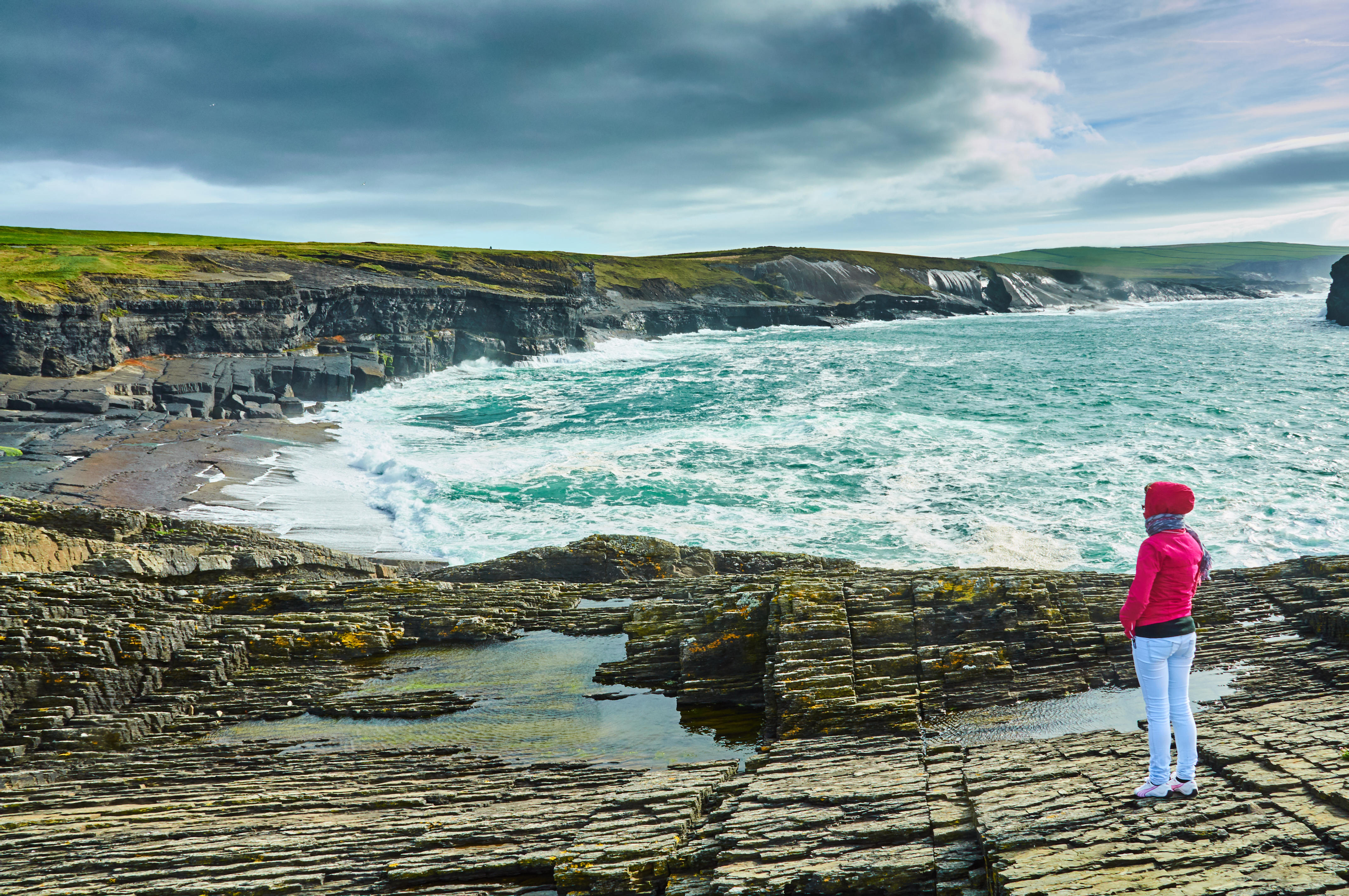 Woman watching ocean waves on The Kilkee Cliff walk 