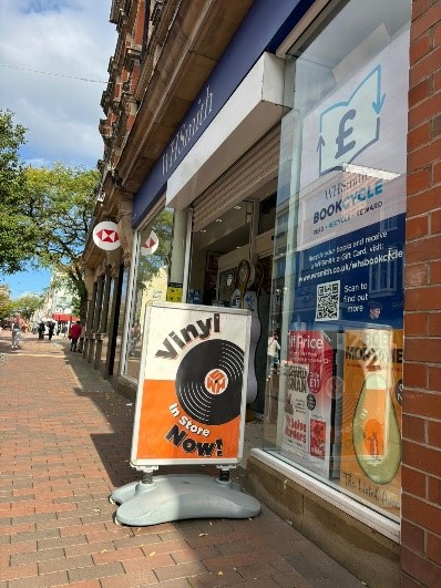 A sign for vinyl records outside a WH Smith store