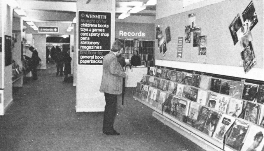 Black and white image of person browsing in a WH Smith record section