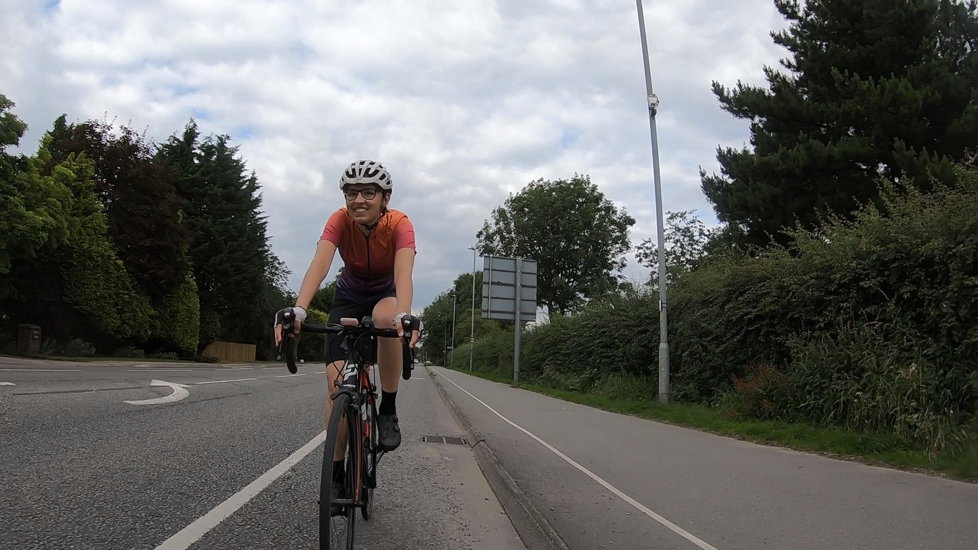 Photo of a woman cycling on an empty main road