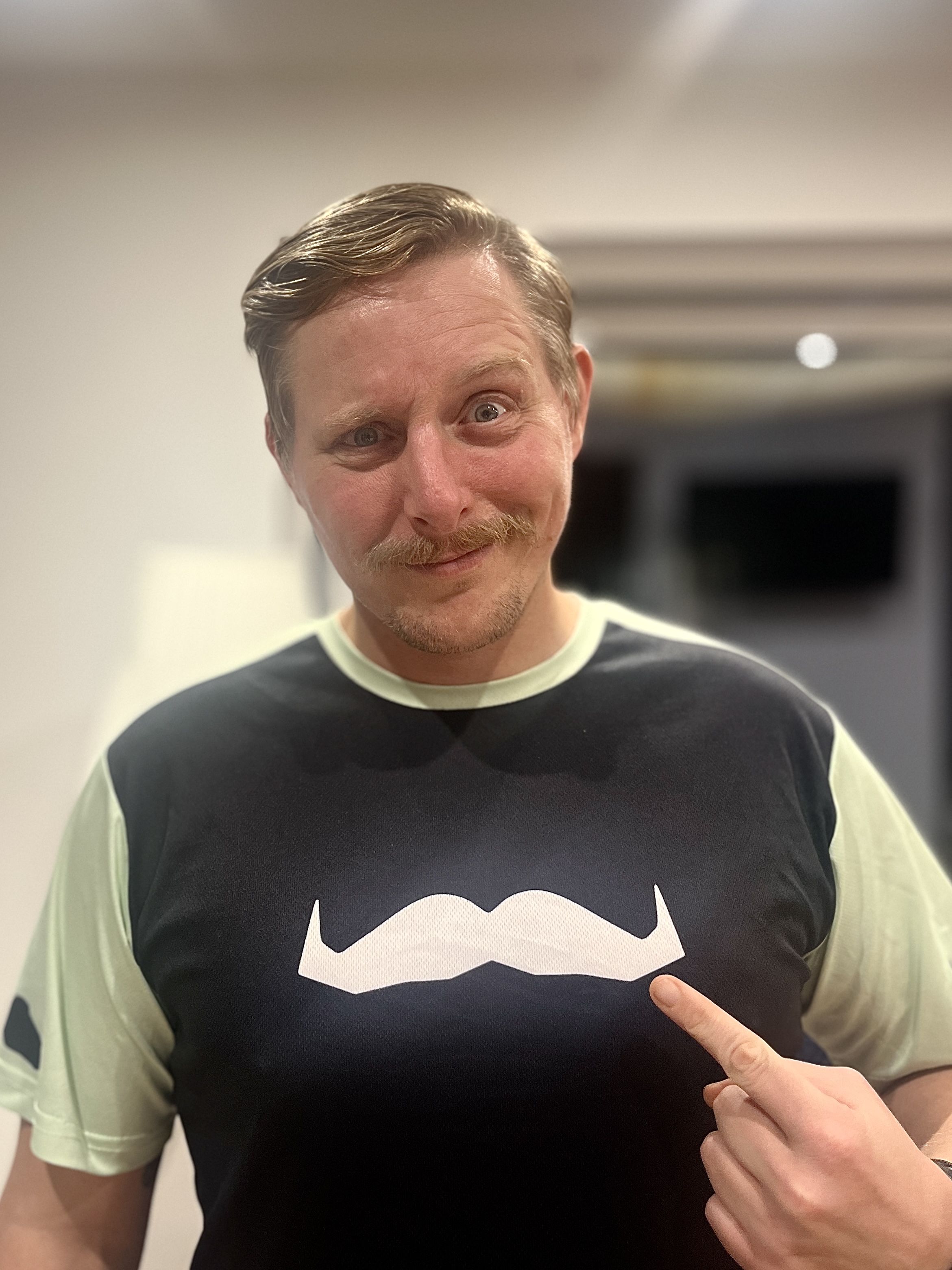 Man with a moustache wearing a T-shirt with a white moustache print