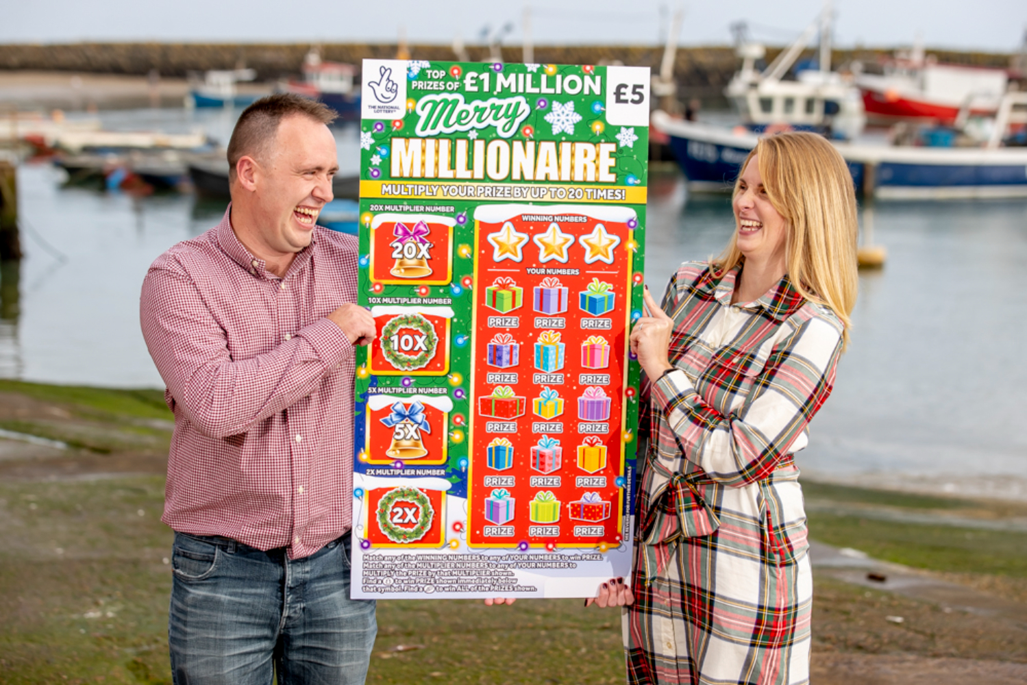 Couple hold a giant scratch card which they won £1 million from