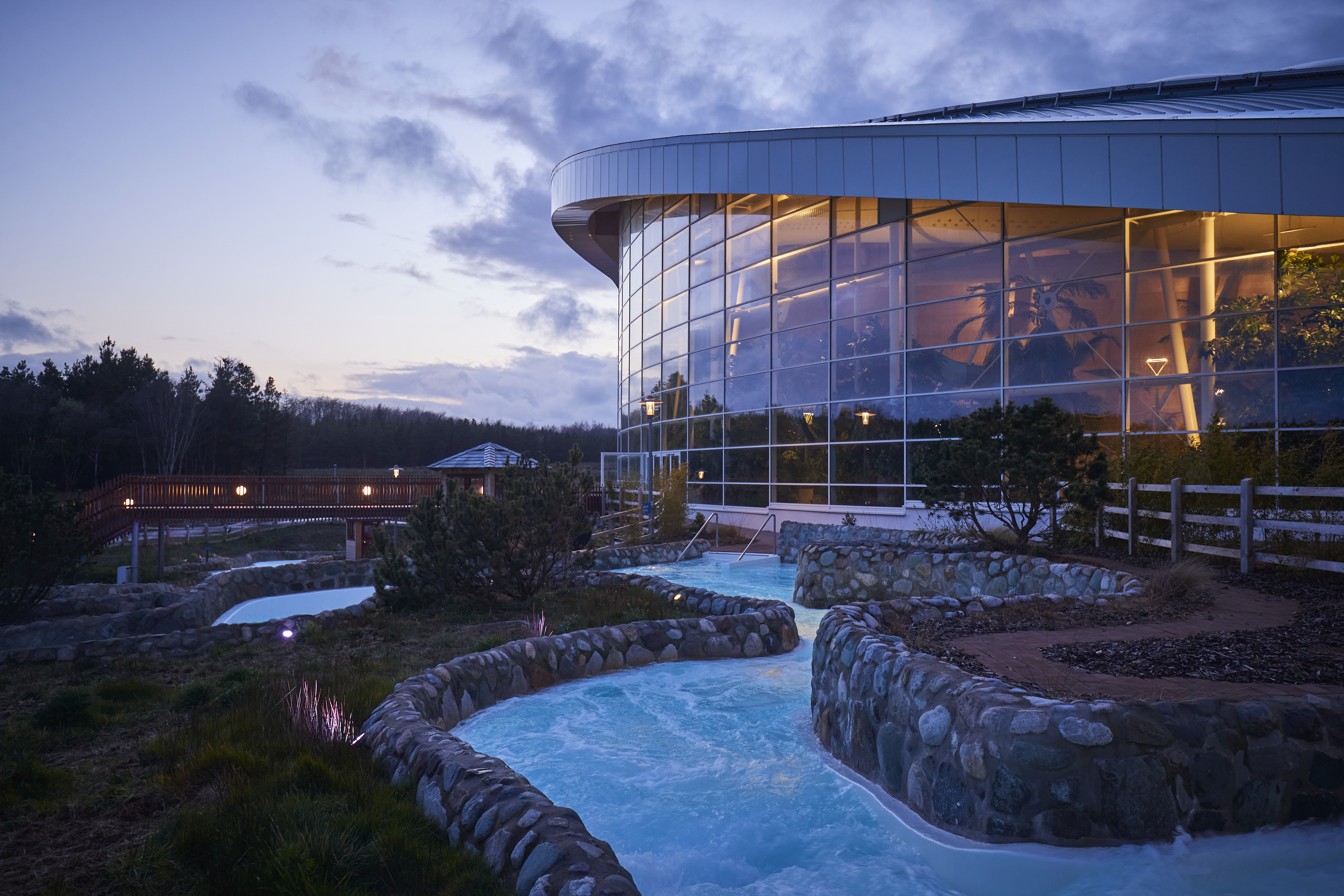 Water rapids in front of a glass-fronted, sloped building